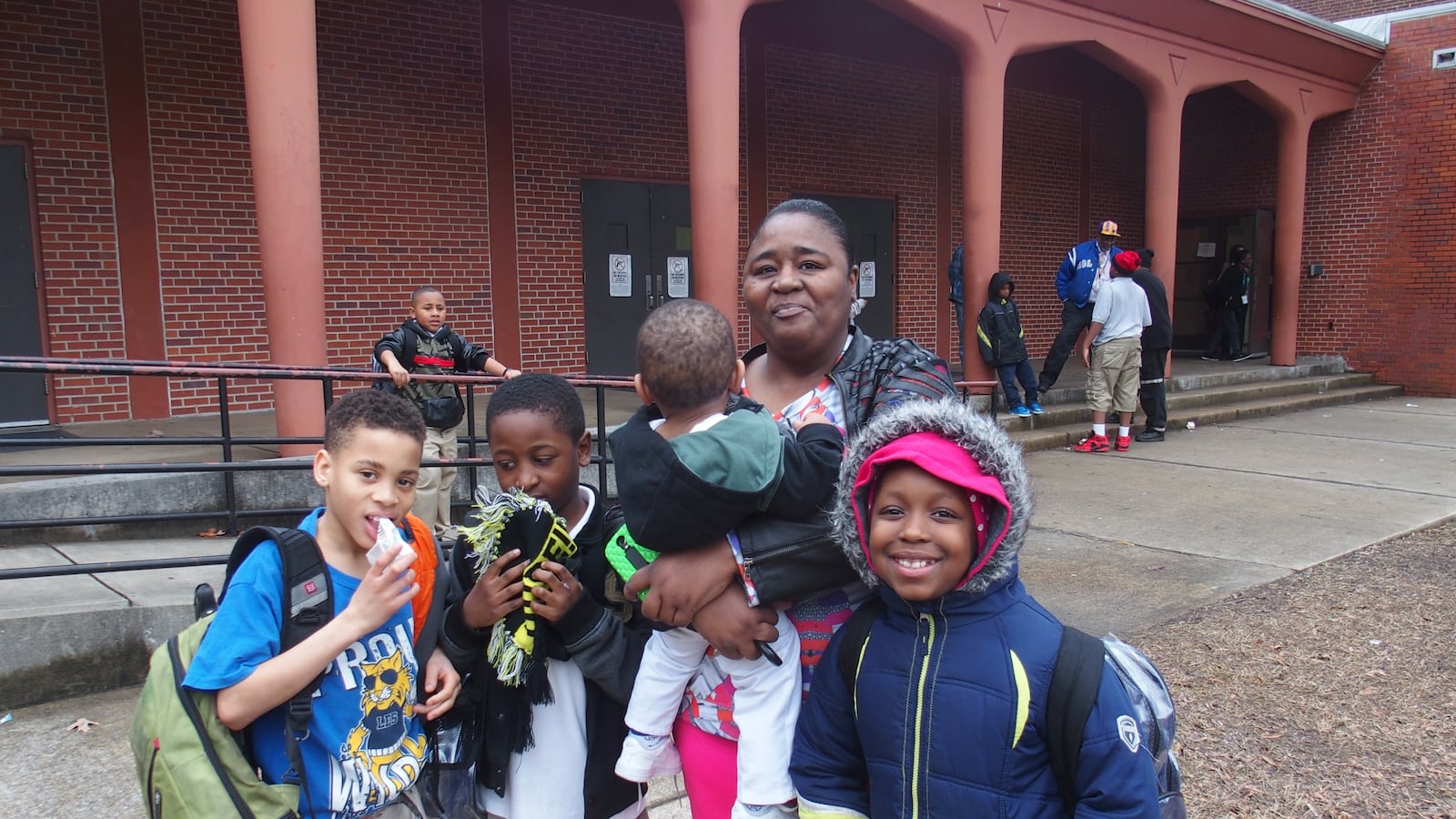 Anita Smith stands with grandson Jaylan Jones (second from left) and his friends in front of Lincoln Elementary School during its last months of operation in 2015. Shelby County Schools is tracking the academic performance of displaced Lincoln students who now attend A.B. Hill Elementary.