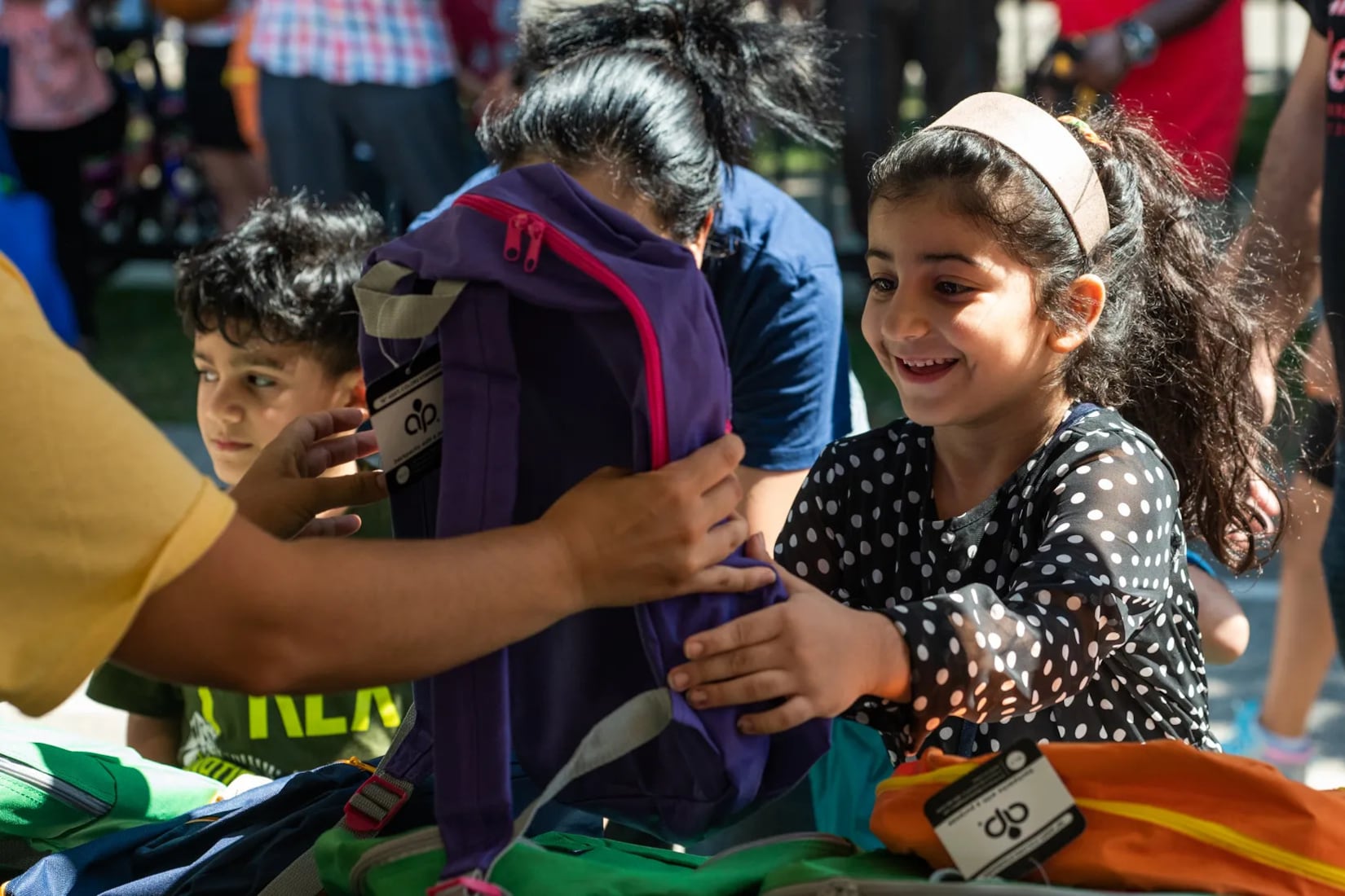 A little girl picks out a new backpack during a back-to-school backpack giveaway at Eugene Field Elementary School in Chicago’s Rogers Park neighborhood on Aug. 5, 2022.