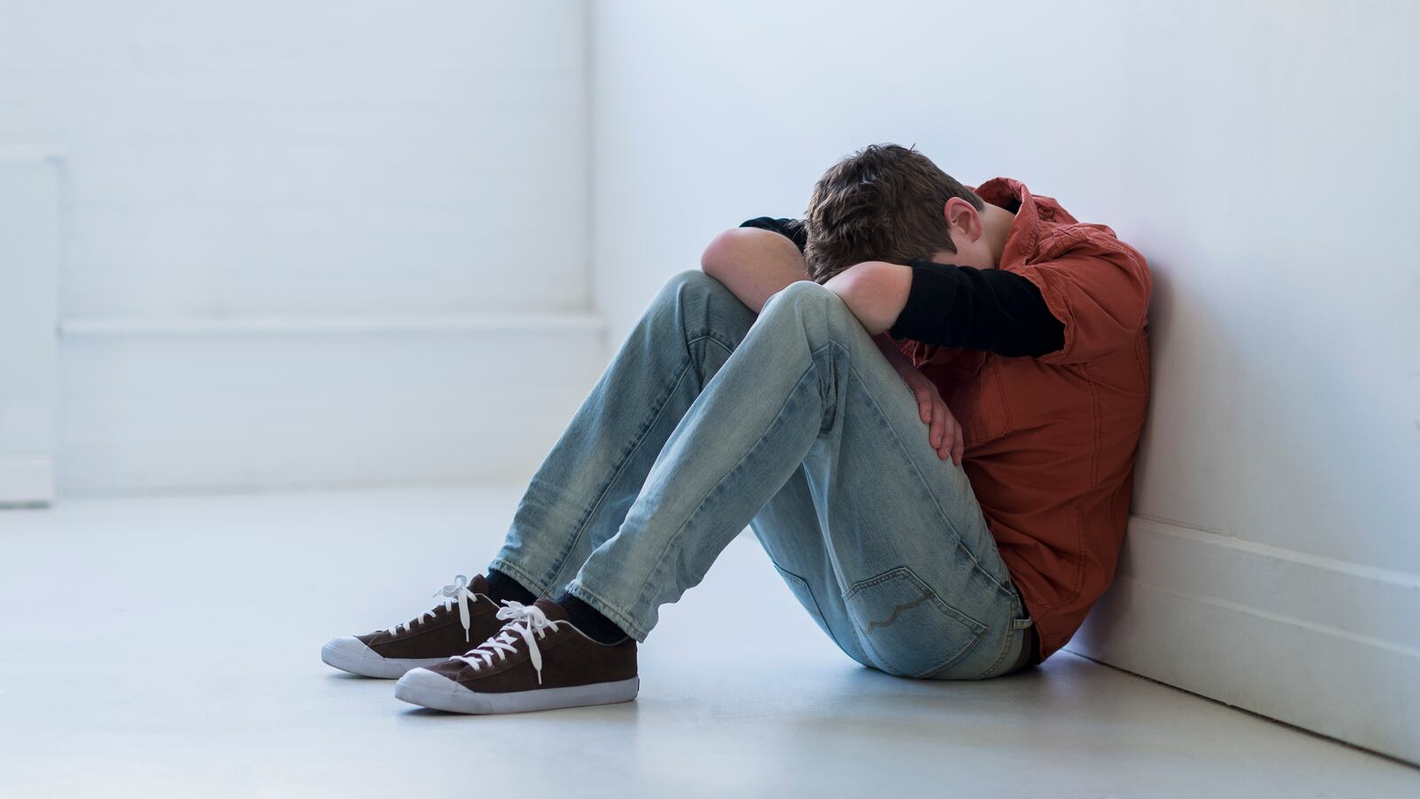 Teenage boy sitting in hallway. (Tetra Images | Getty Images)