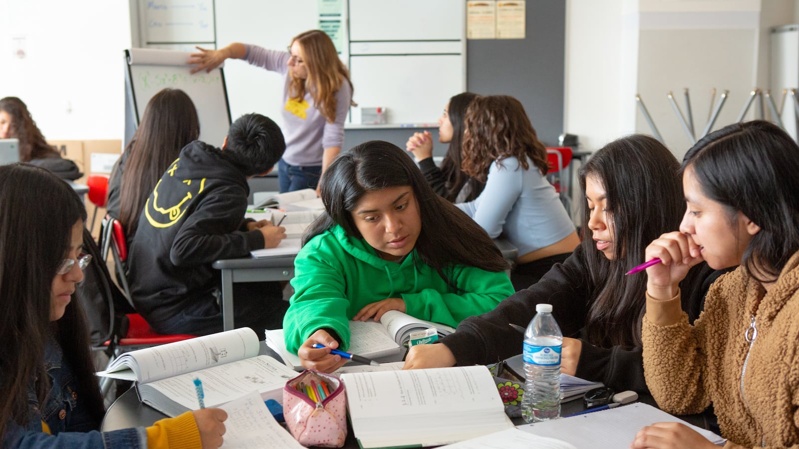 A group off high school students work together in a classroom.