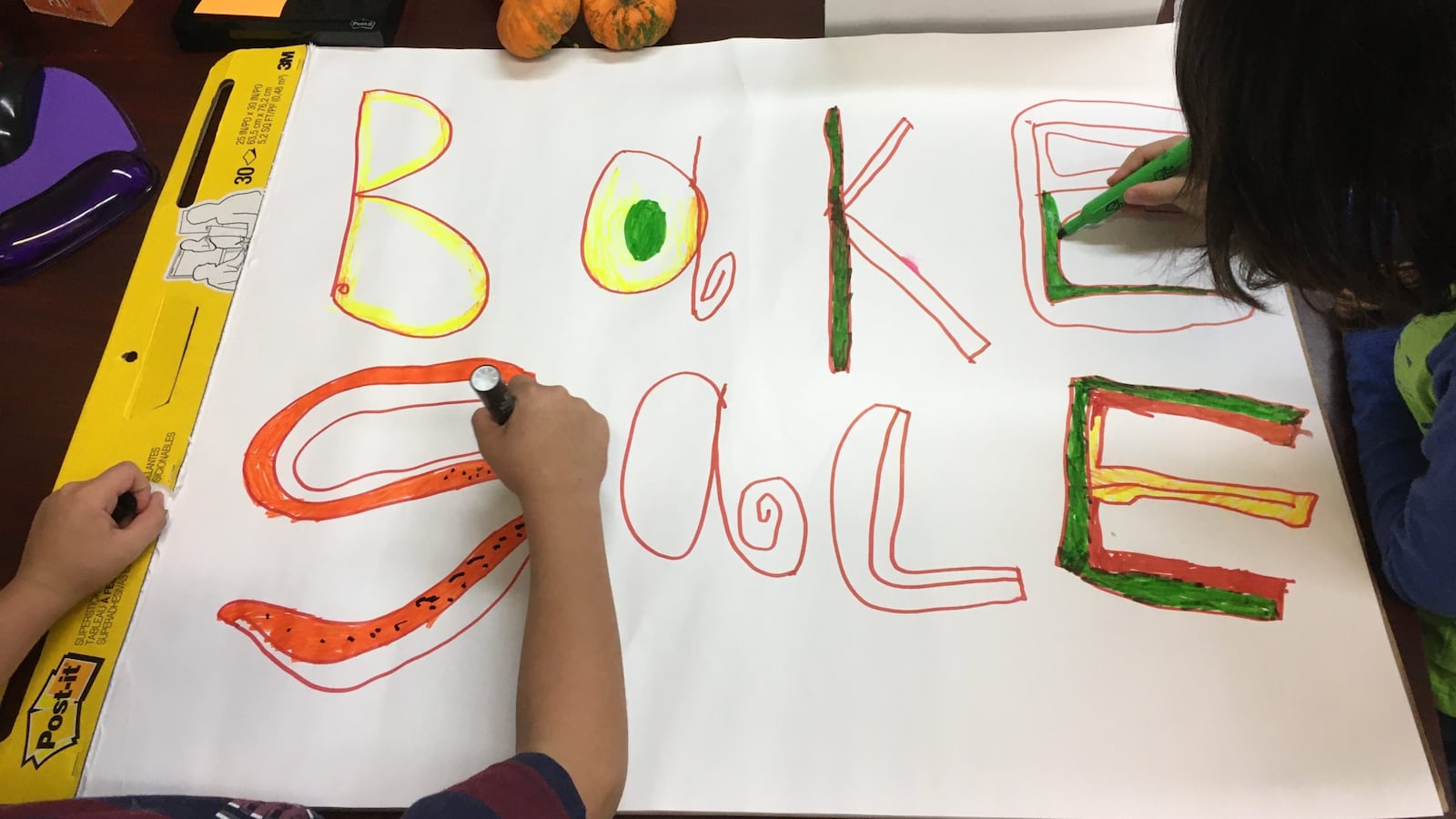Children help color a bake sale sign for a PTA fundraiser at New York City’s P.S. 165.