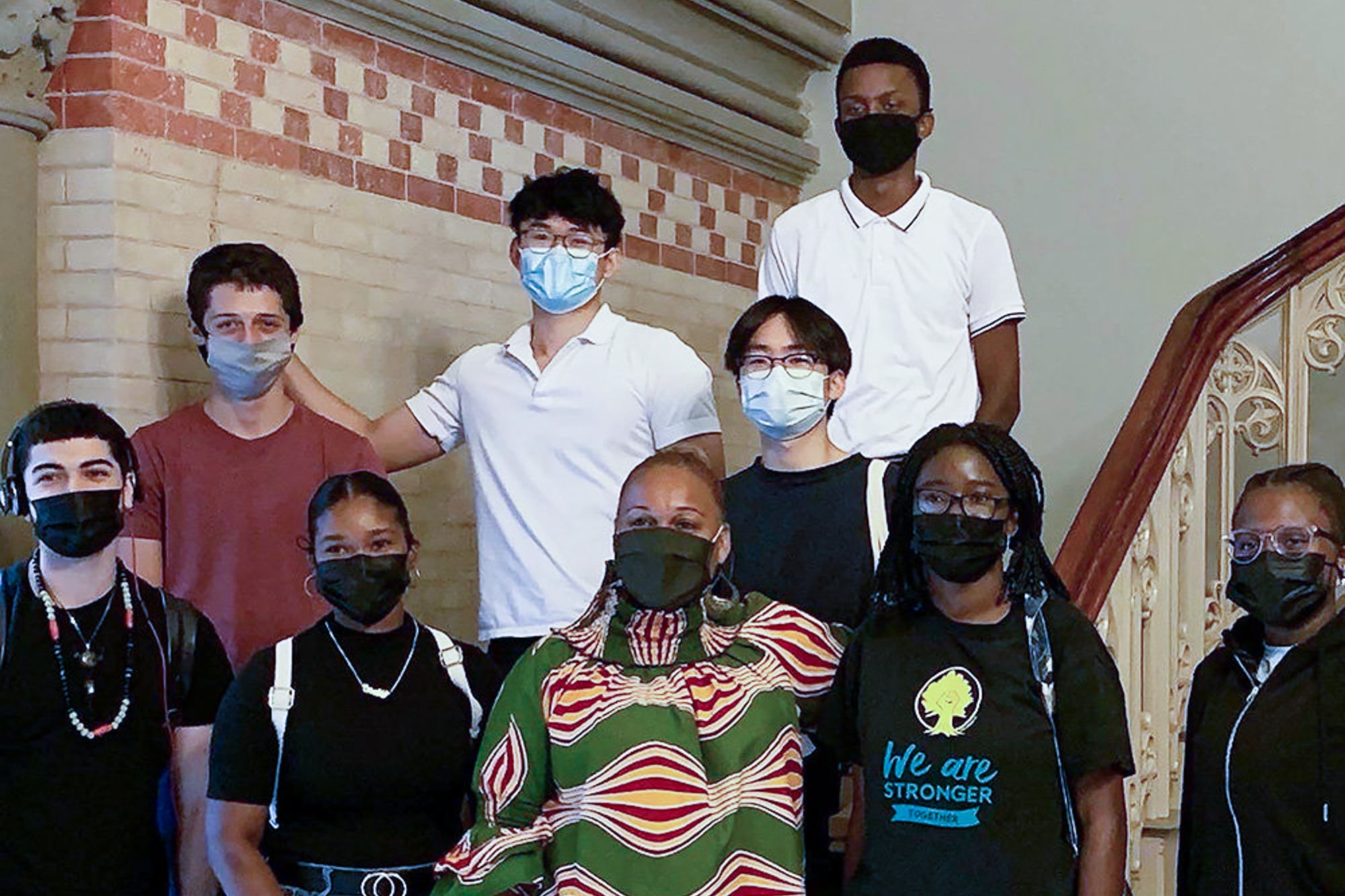 A group of students pose for a group portrait with New York City Schools Chancellor Meisha Porter on a stairwell.