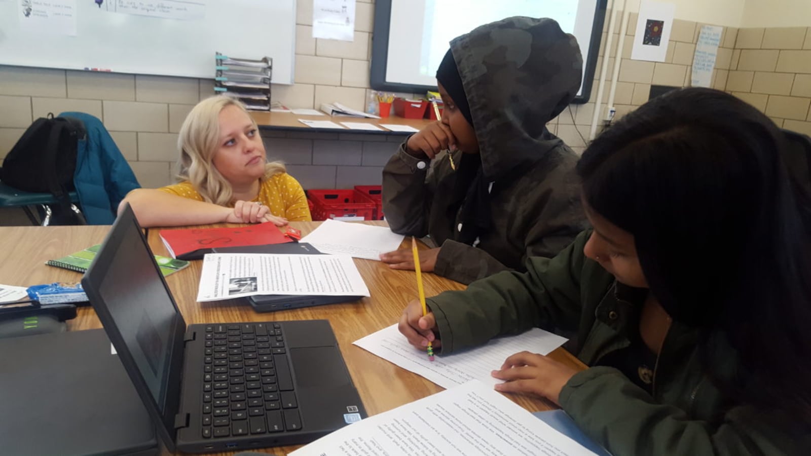 A teacher works with ninth grade students in an English Language Arts class at Aurora Central High School.