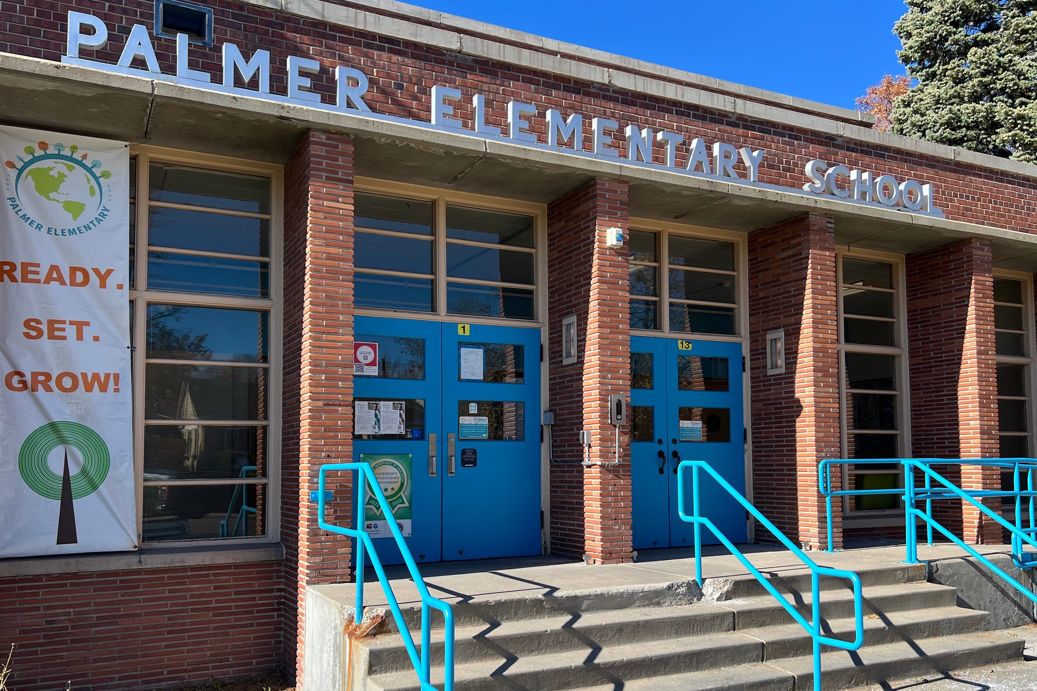 The front entrance to a brick school building with a title that reads "Palmer Elementary School."
