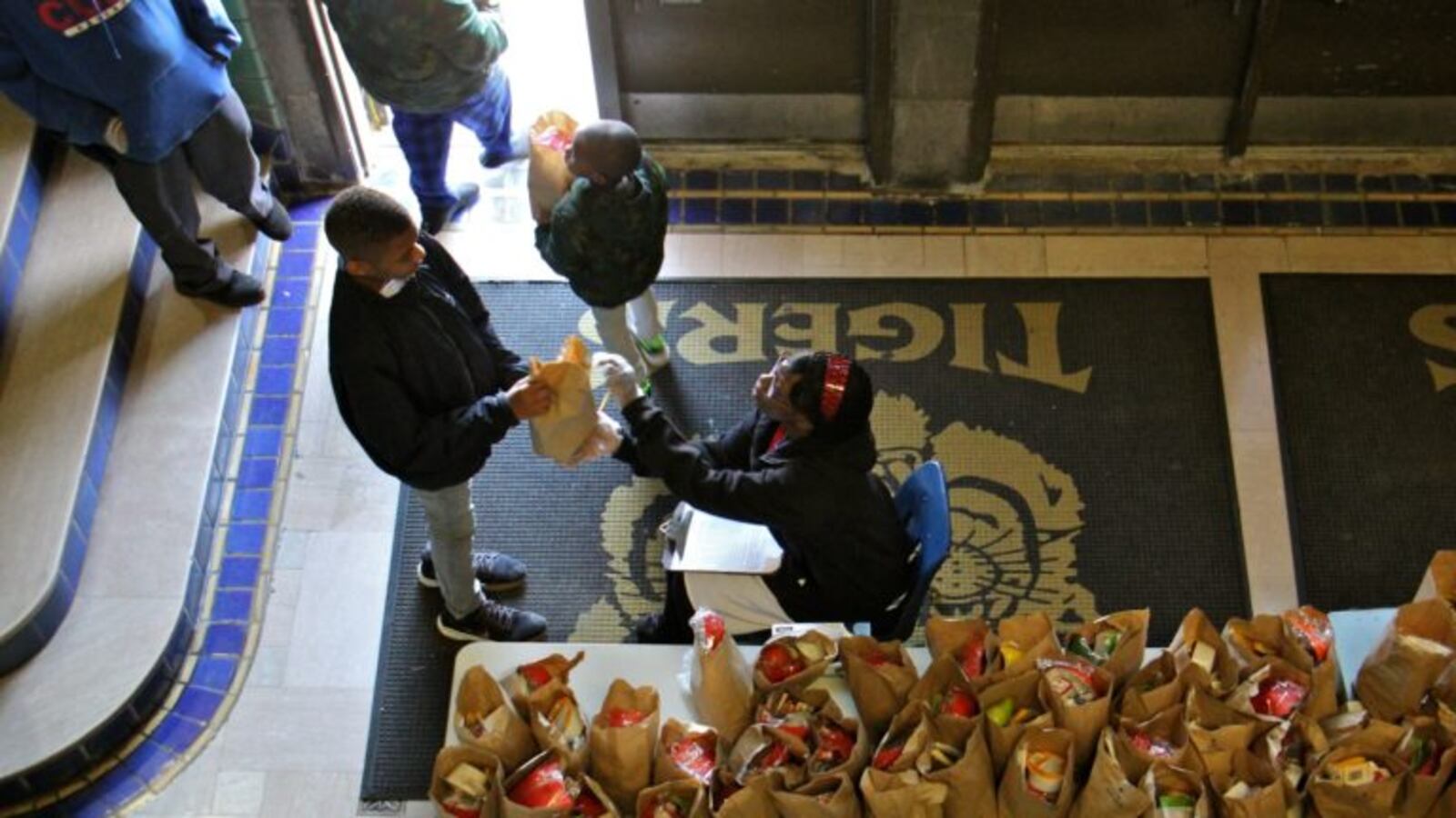 Daaiyah Boone hands out bagged meals to students at Tilden Middle School during the coronavirus shutdown.