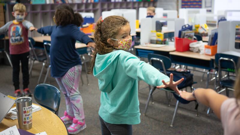 Students create distance between each other using their arms as they line up to go outside in Mrs. Cecarelliís second grade class at Wesley Elementary School in Middletown, CT, October 5, 2020.
