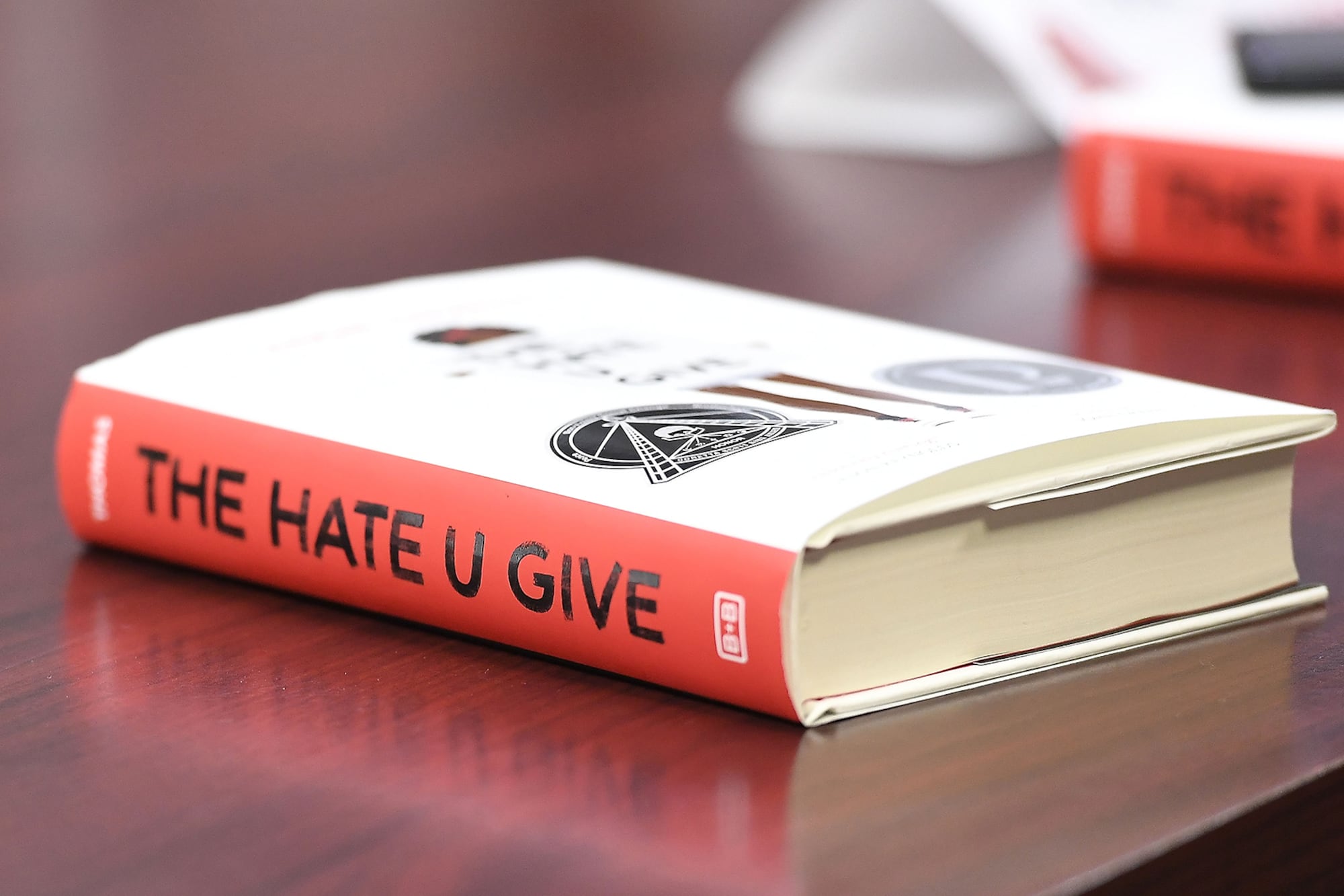 A red and white book on a brown table.