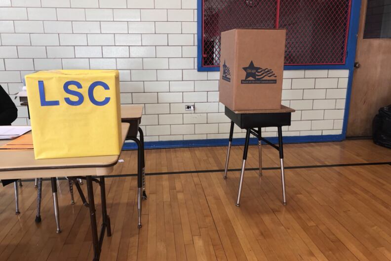 Two boxes for ballots at Yates Elementary in Chicago: The yellow box is for mail-in ballots dropped off at the campus and the brown box is for votes cast on site.