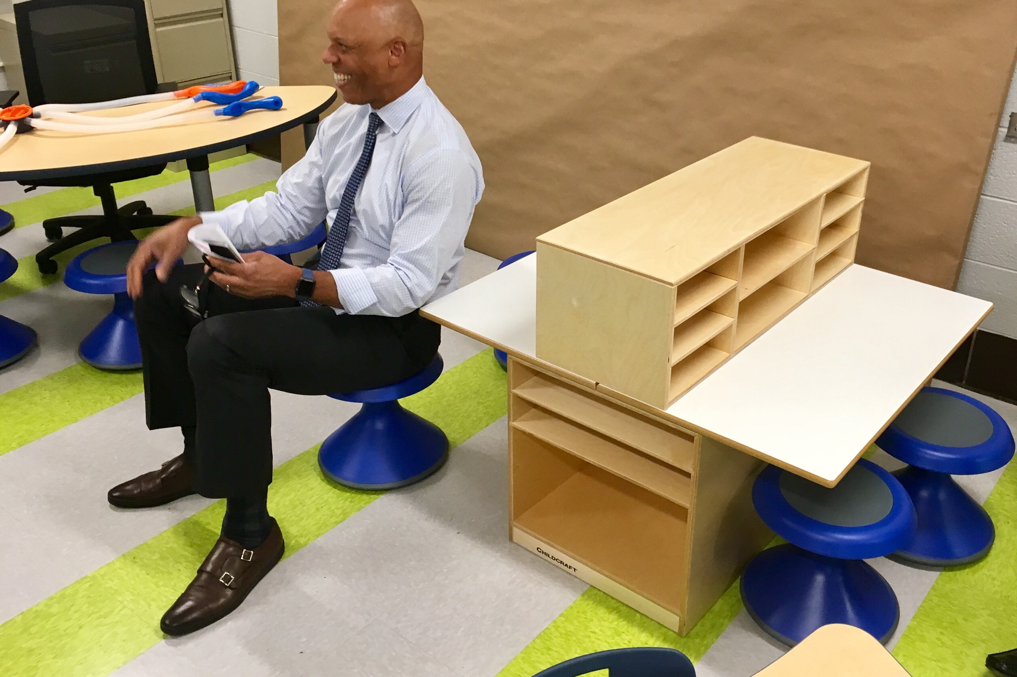 Superintendent William Hite sitting on a wobble seat and smiling.