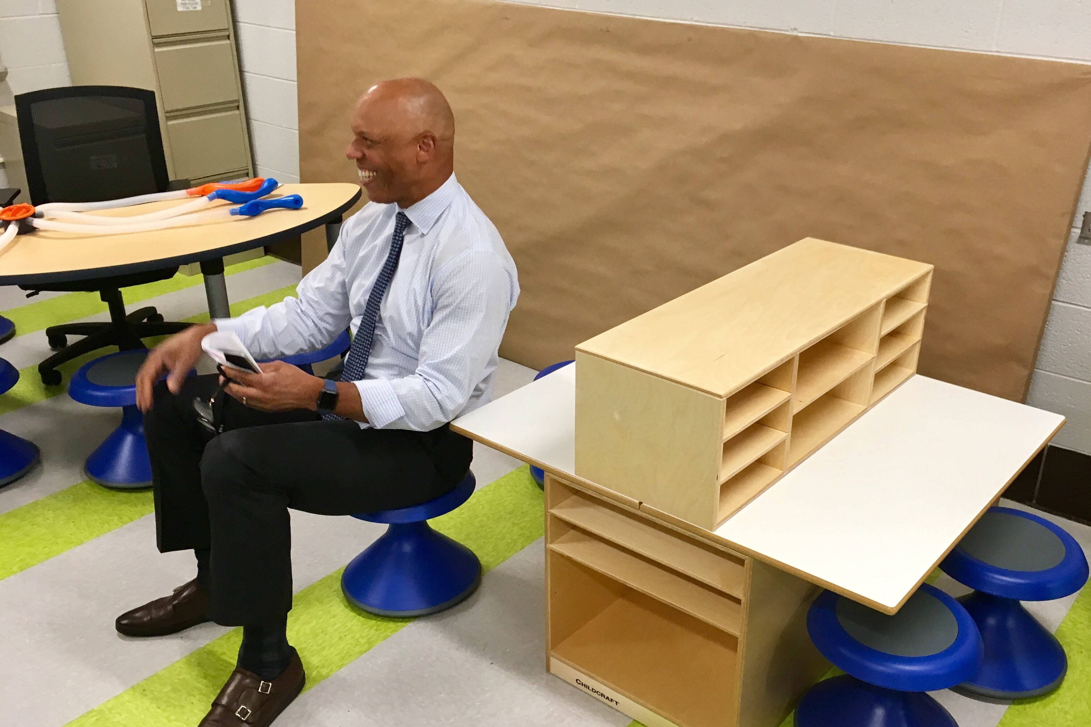 Superintendent William Hite sitting on a wobble seat and smiling.