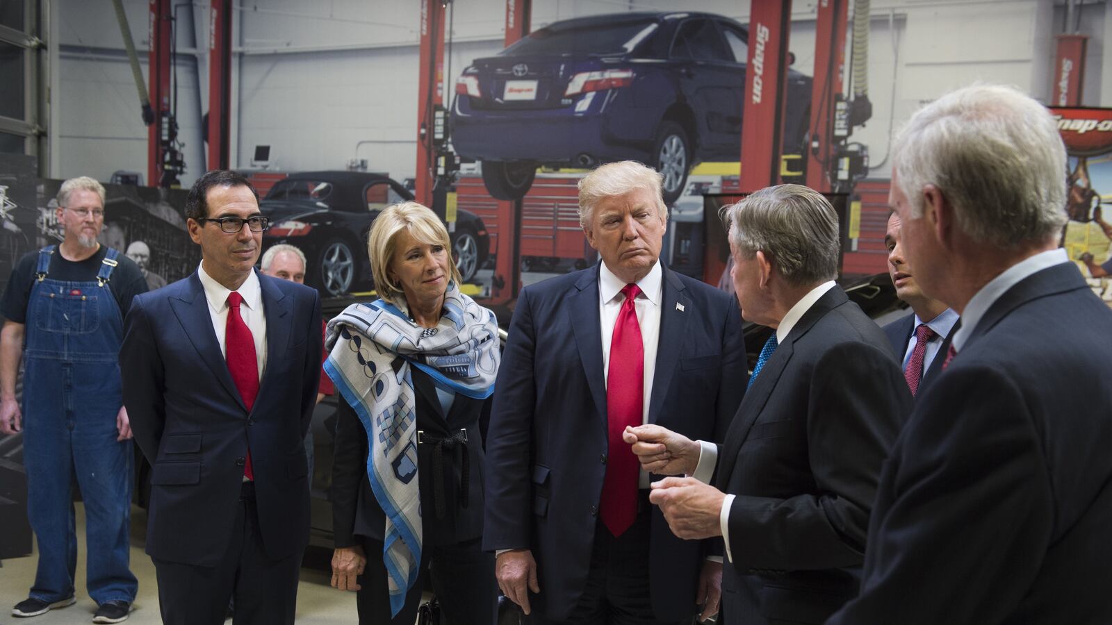 US President Donald Trump tours Snap-On Tools alongside Snap-On CEO Nick Pinchuk (2nd R), Secretary of Treasury Steve Mnuchin (L) and Secretary of Education Betsy DeVos (2nd L) in Kenosha, Wisconsin, April 18, 2017, prior to signing the Buy American, Hire American Executive Order. (Photo credit: SAUL LOEB/AFP/Getty Images)