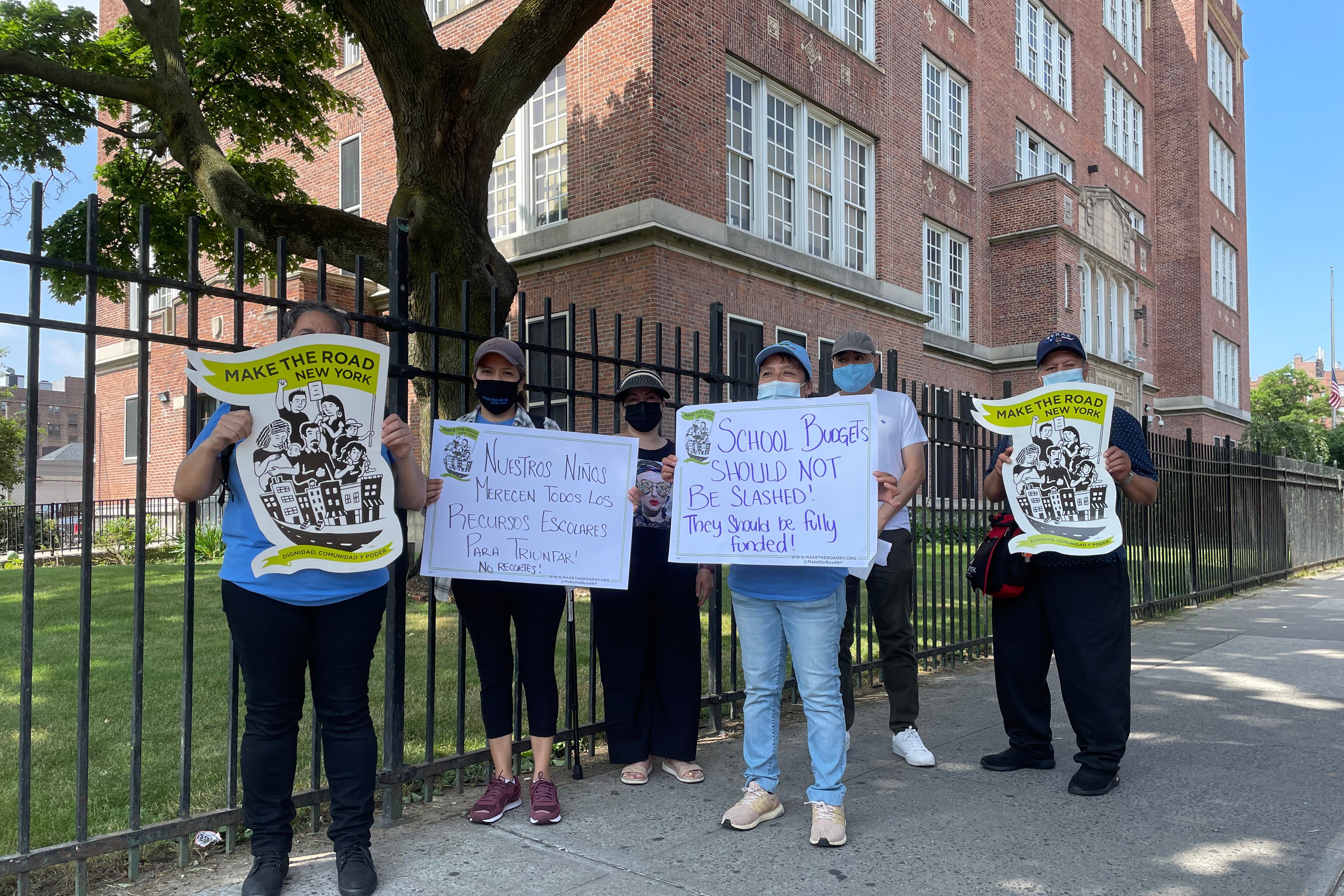 People stand outside with protest signs