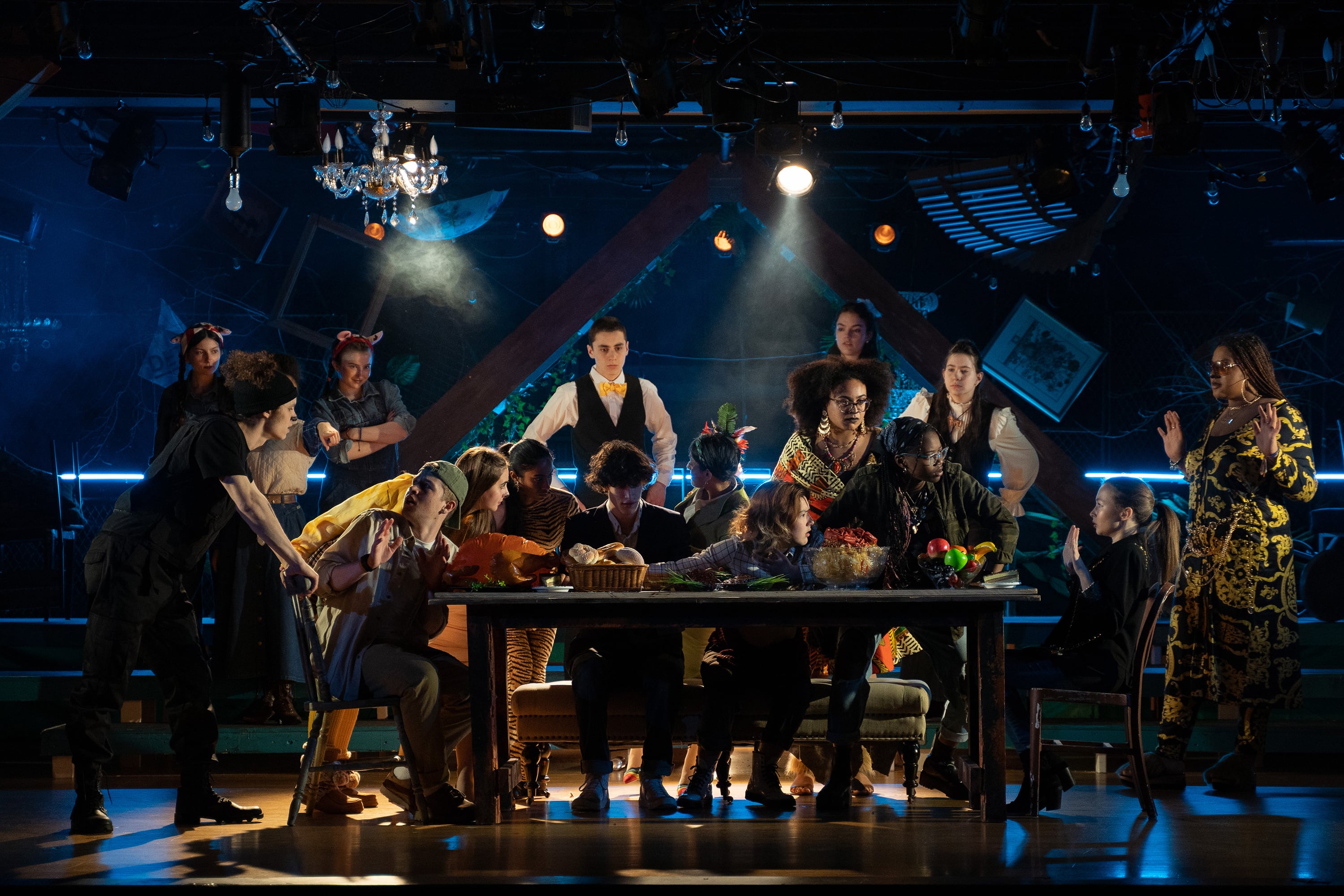A group of high school students in costume on stage during a production of "Kill the Messenger."