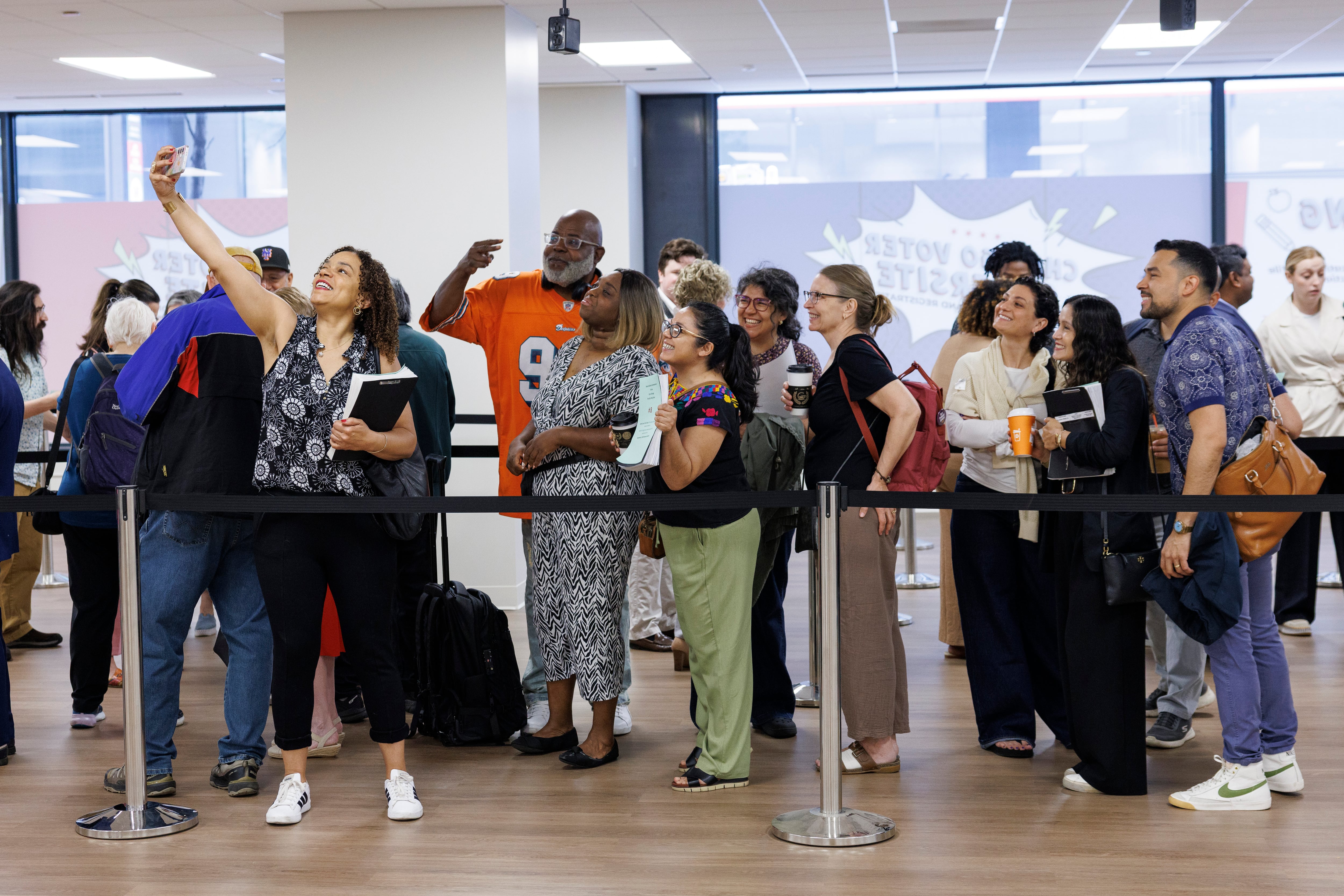 A group of adults stand in a line in a room.