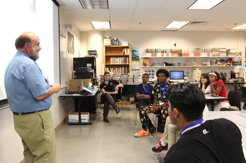 Students look on as a CU Denver physics instructor talks to them about physics and space. Physics was one of six majors students could explore during breakout sessions.