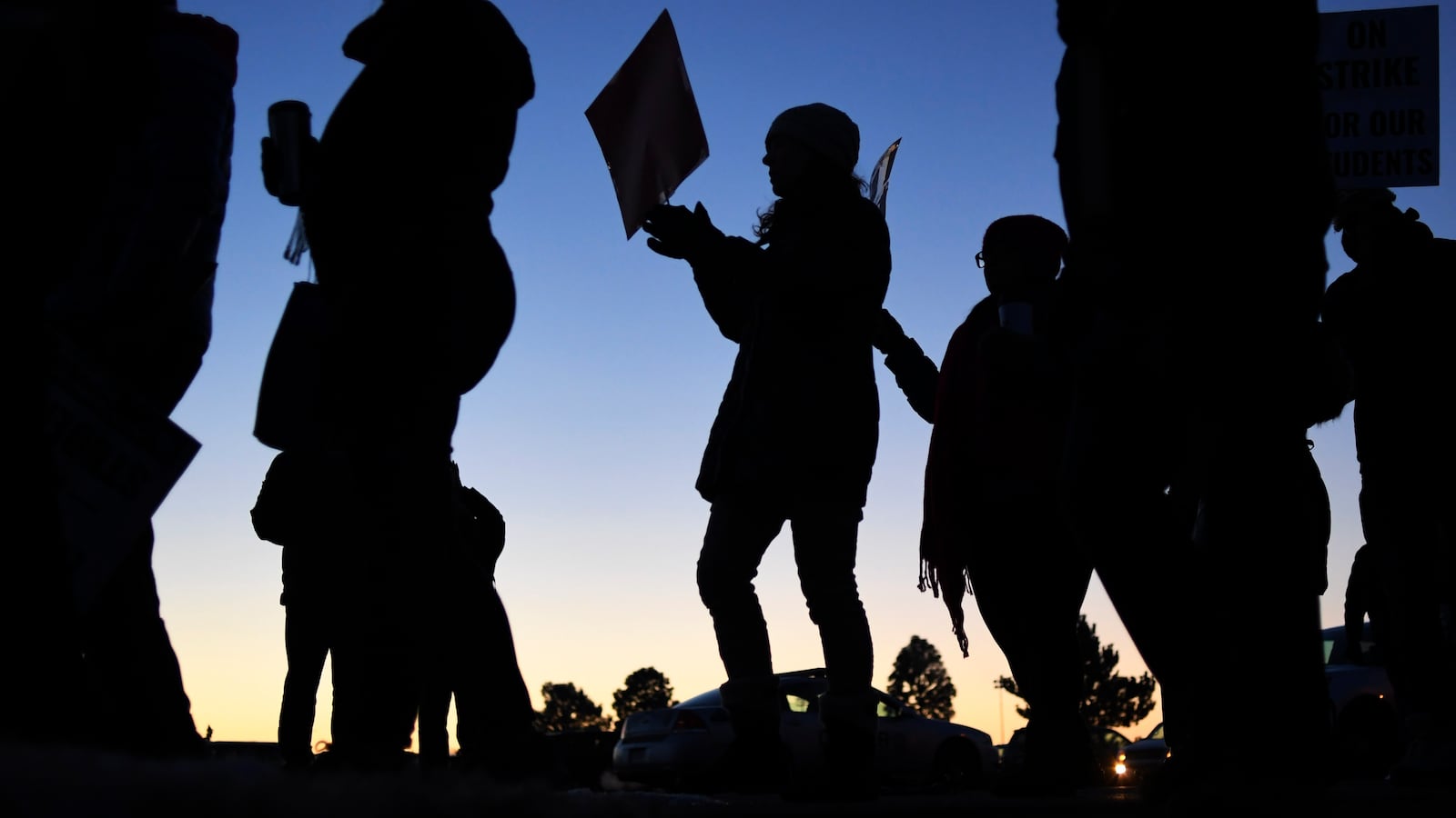 A silhouette of Denver teachers walking the picket line during the 2019 teachers strike.
