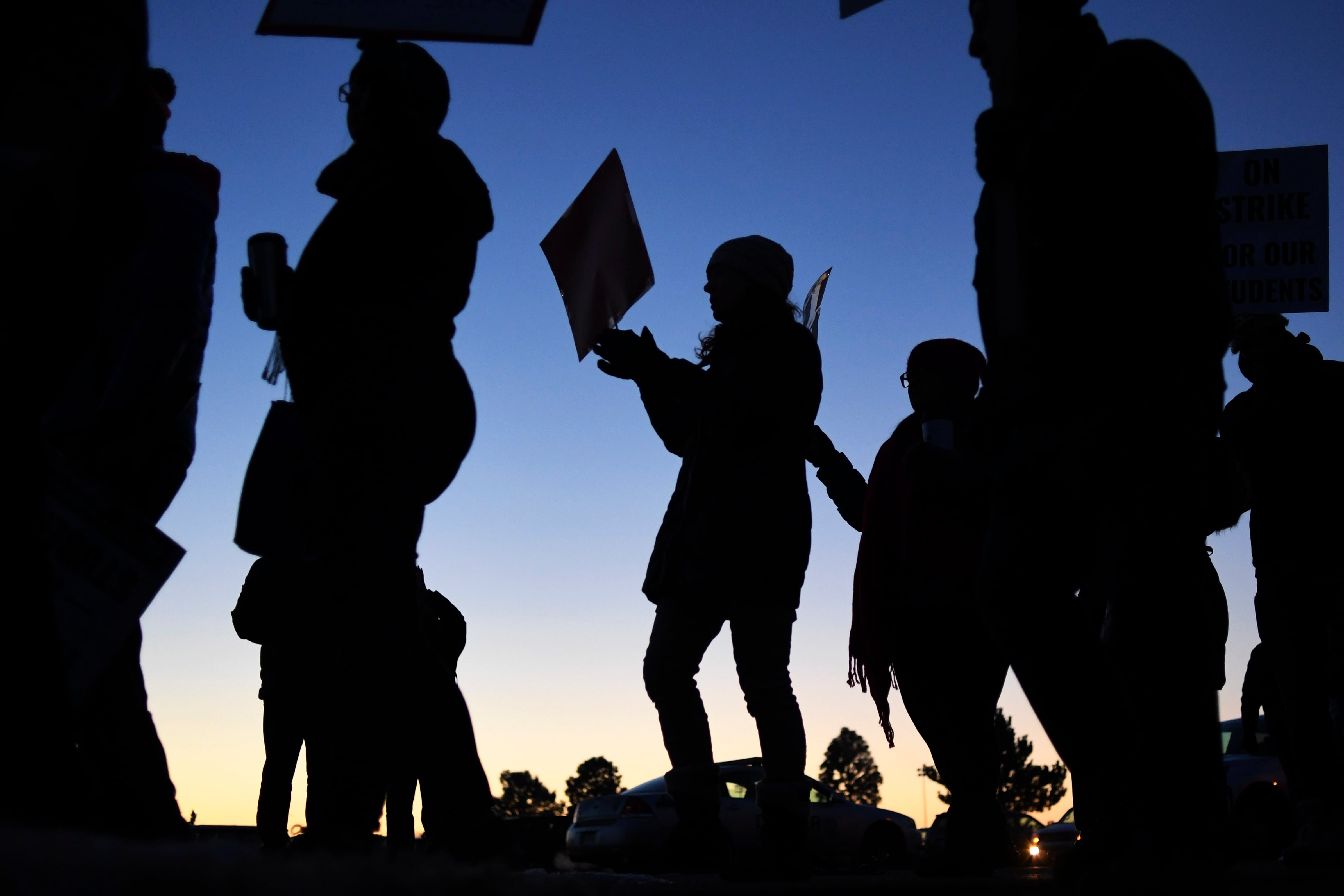 A silhouette of Denver teachers walking the picket line during the 2019 teachers strike.