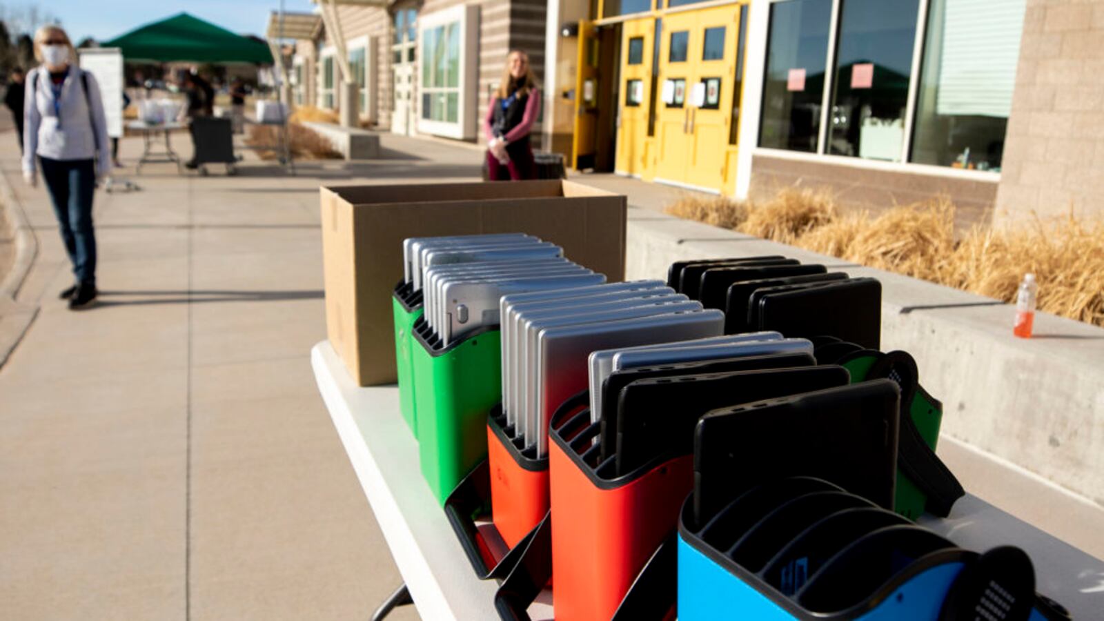 Staff distribute laptops to families at Denver's Joe Shoemaker School on March 25, 2020, as schools prepare for remote learning.