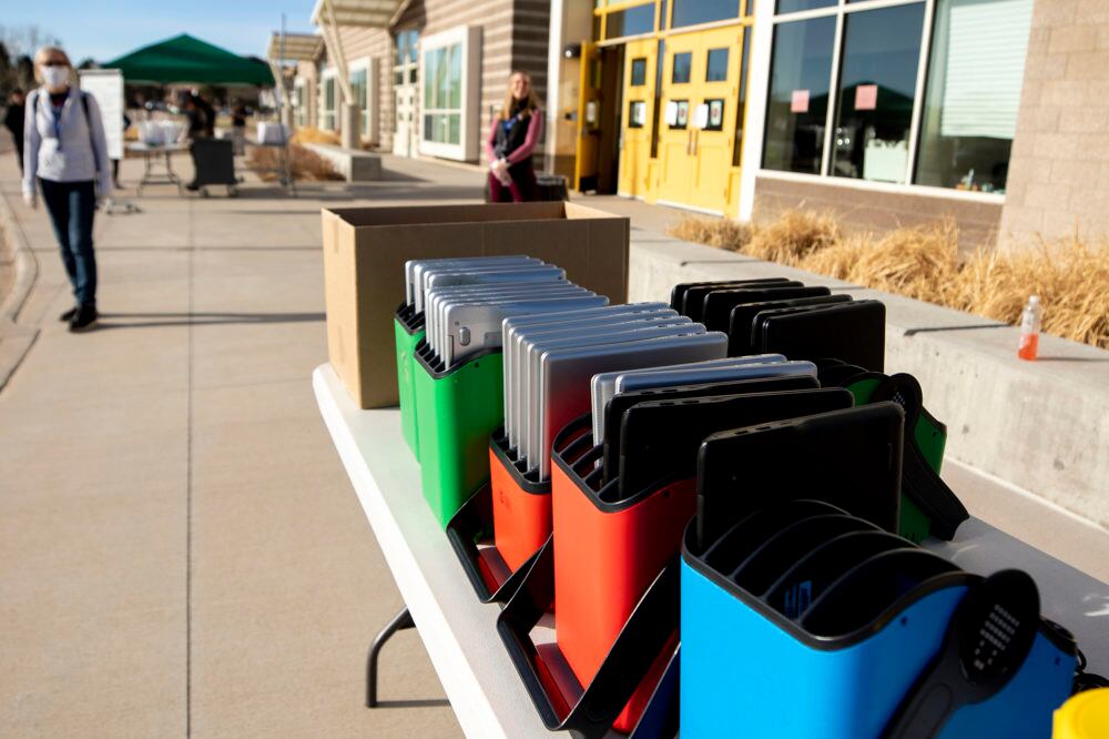 Staff distribute laptops to families at Denver's Joe Shoemaker School on March 25, 2020, as schools prepare for remote learning.