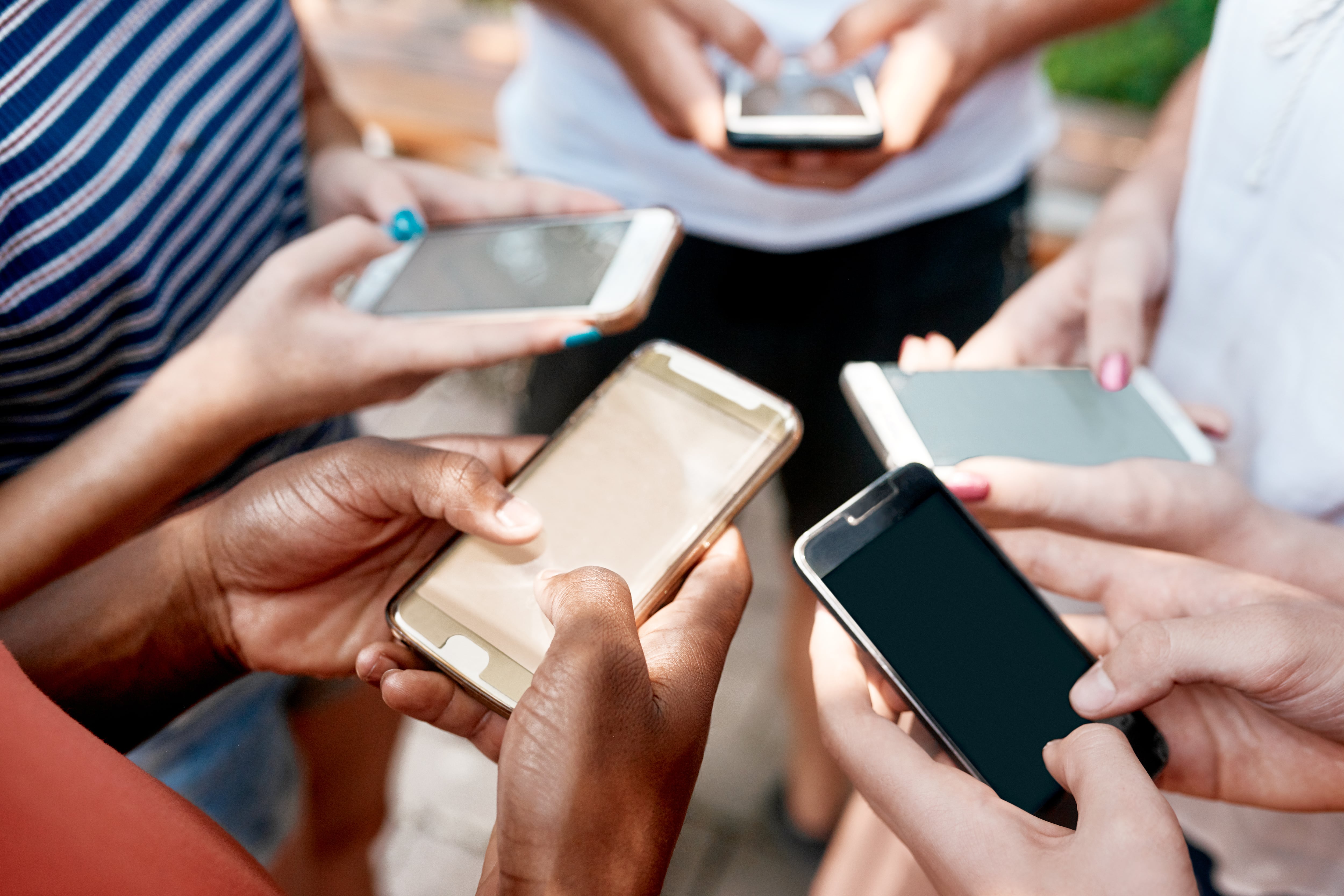 A bunch of hands hold cellphones