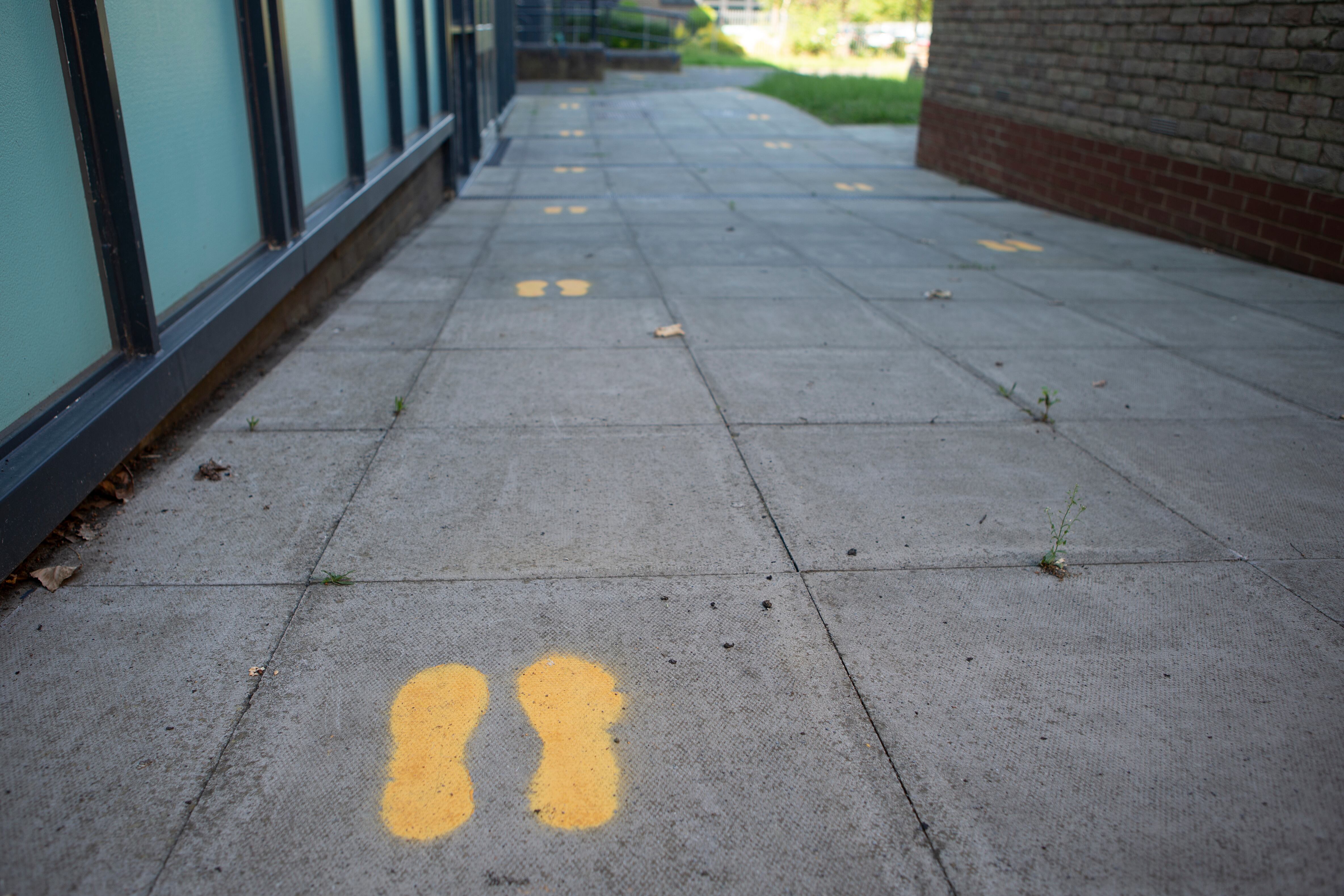 Footprints on the ground in an England school direct students where to go.