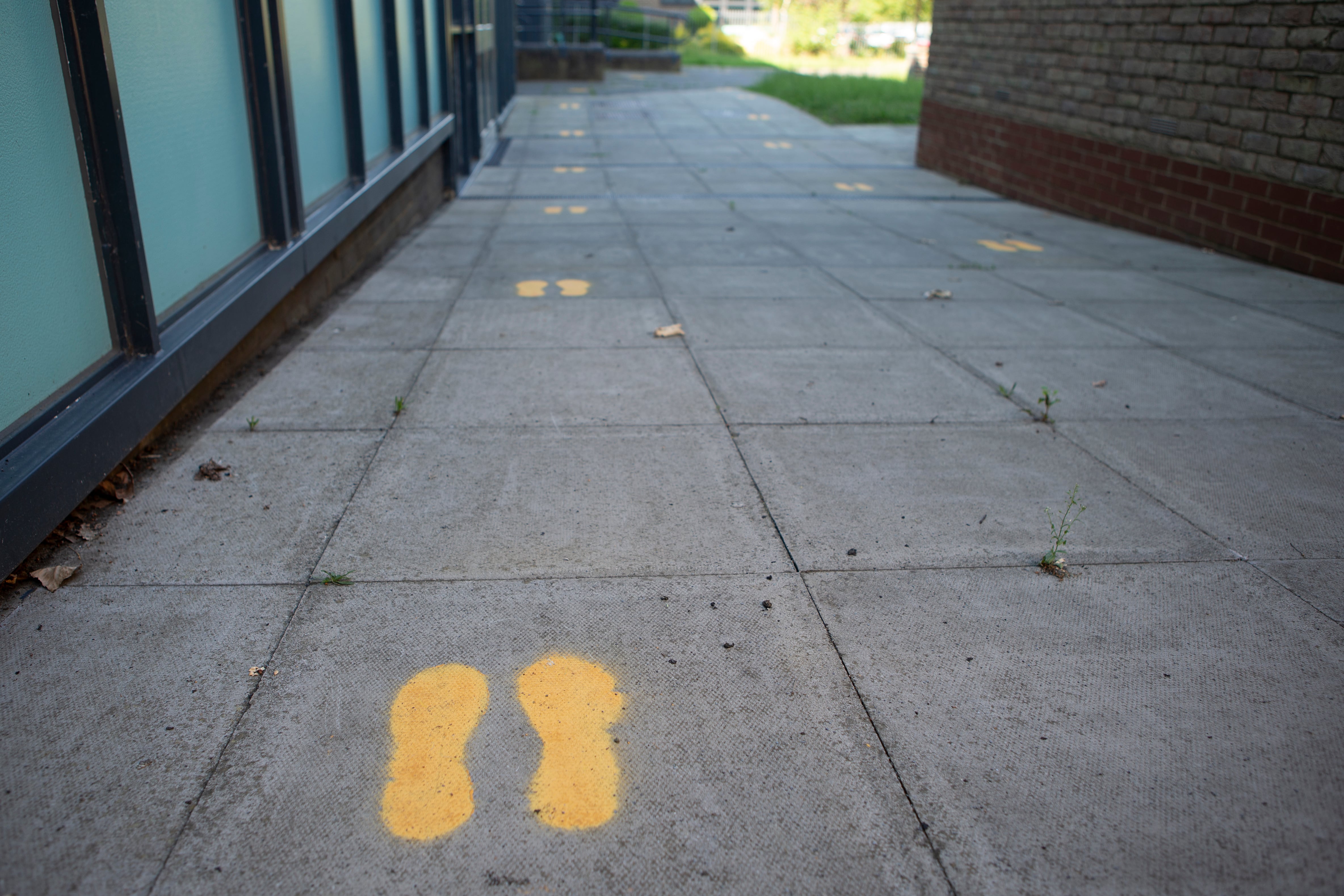 Footprints on the ground in an England school direct students where to go. 
