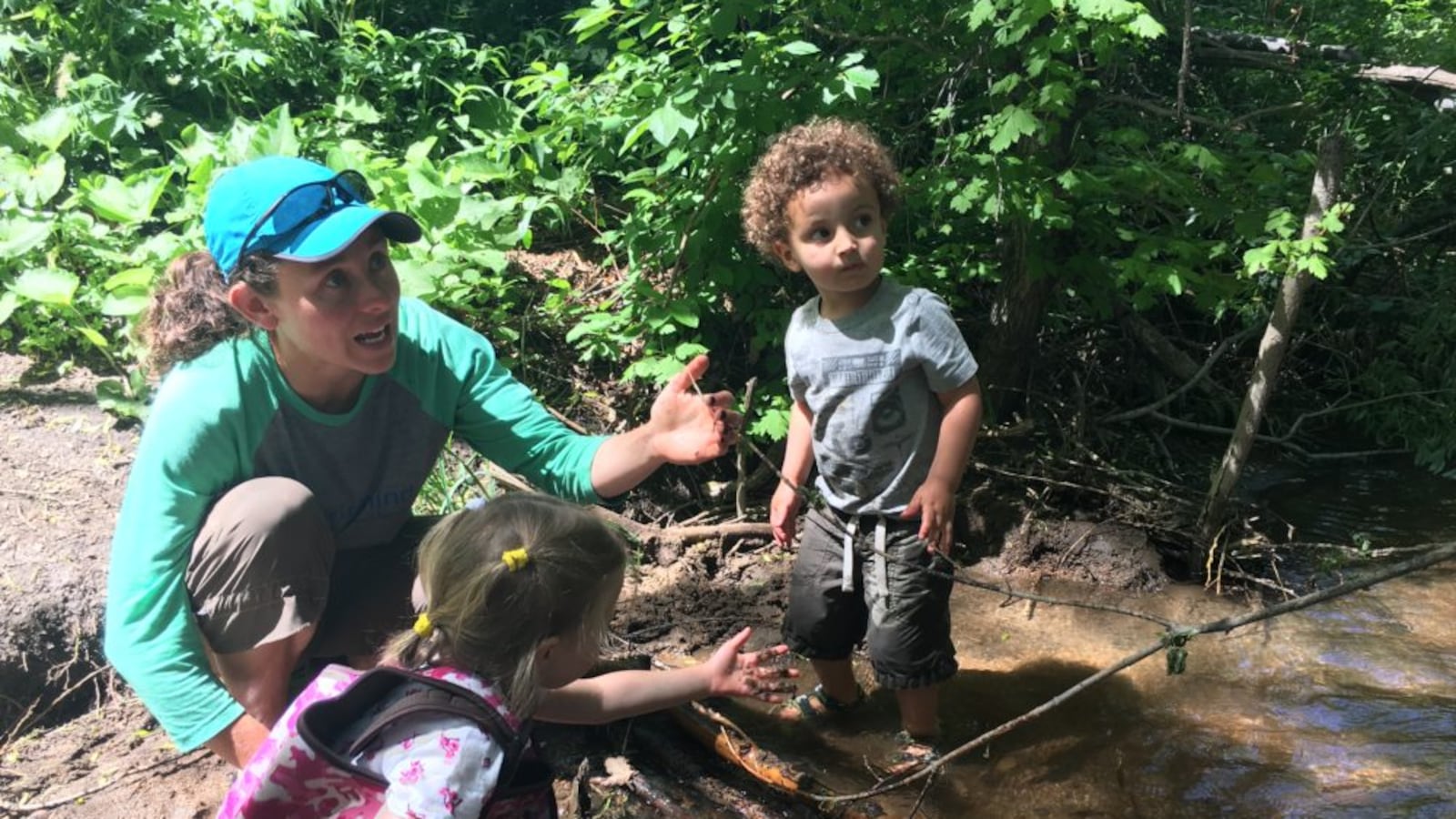 Megan Patterson works with children to make a dam in a creek during a recent “forest school” class.
