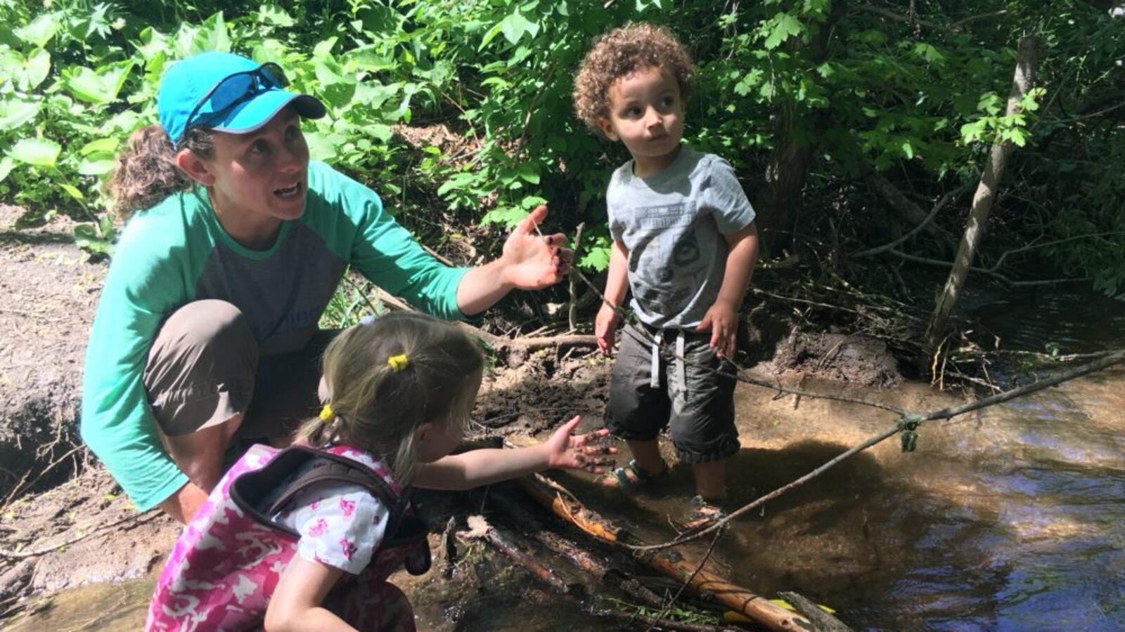 Megan Patterson works with children to make a dam in a creek during a recent “forest school” class.