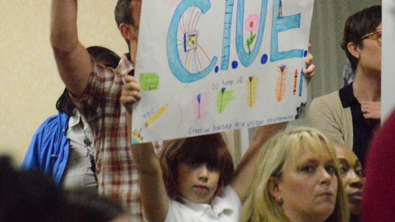 CLUE supporters hold up signs at a budget work session on April 6 when Shelby County's school board began reviewing a proposed spending plan that would cut $50 million from district programs and classrooms.