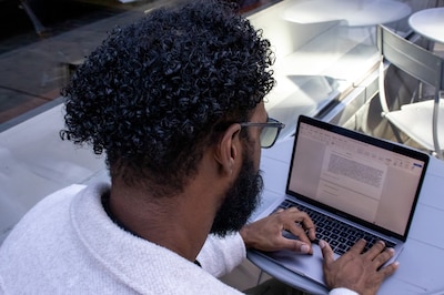 A student works on their laptop outside.