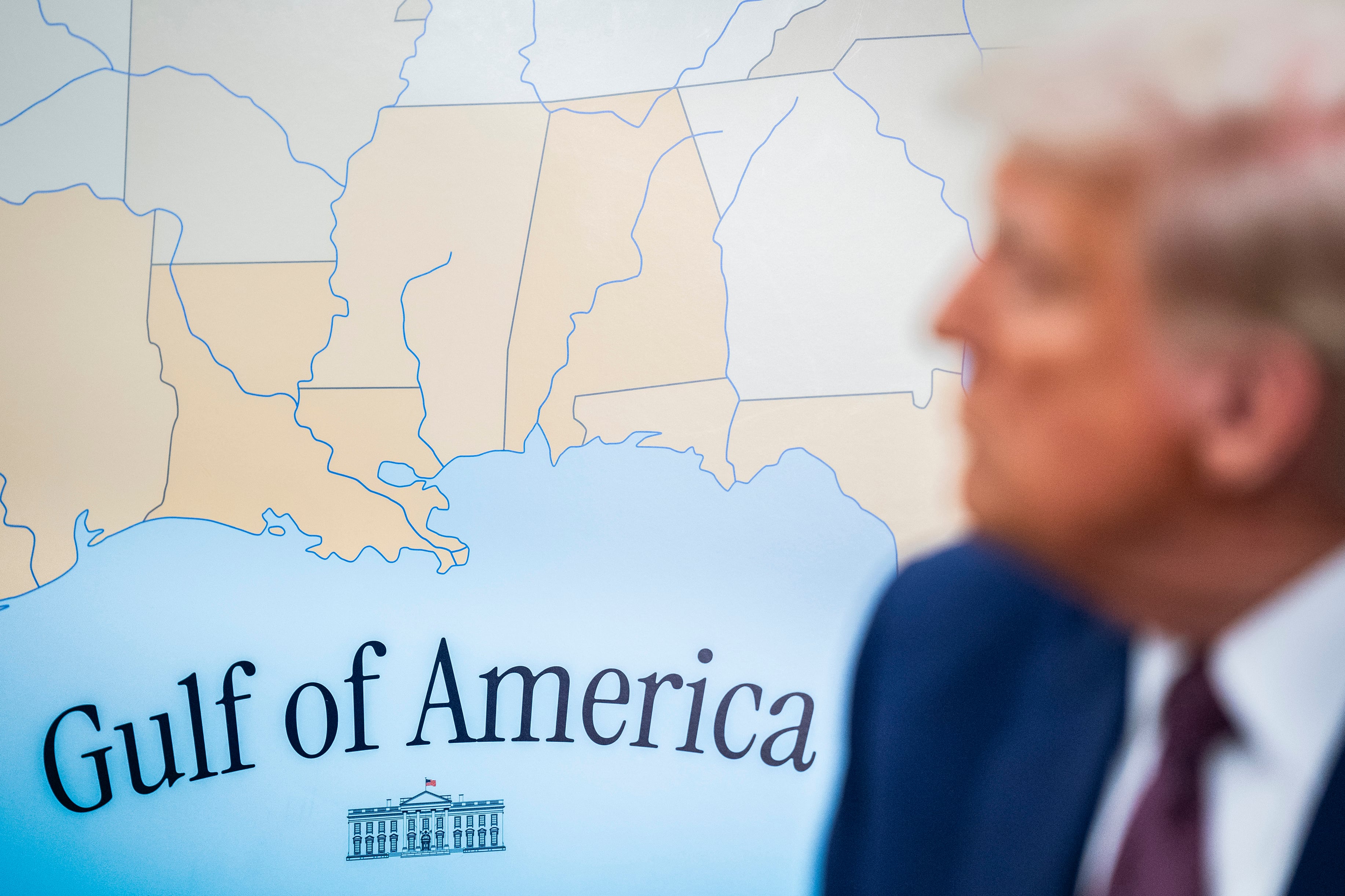 A map of the United States shows words that read "Gulf of America" and a drawing of the white house with a blurry close up of Trump's face.