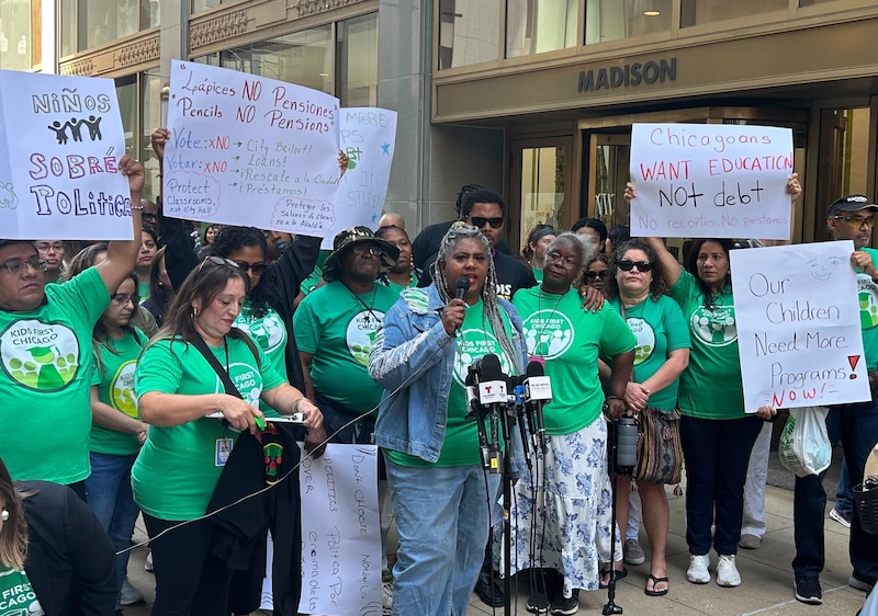 A photograph of a group of adults in green shirts outside.