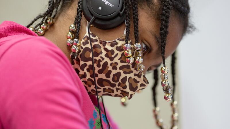 Close up of a student wearing a mask and headphones.