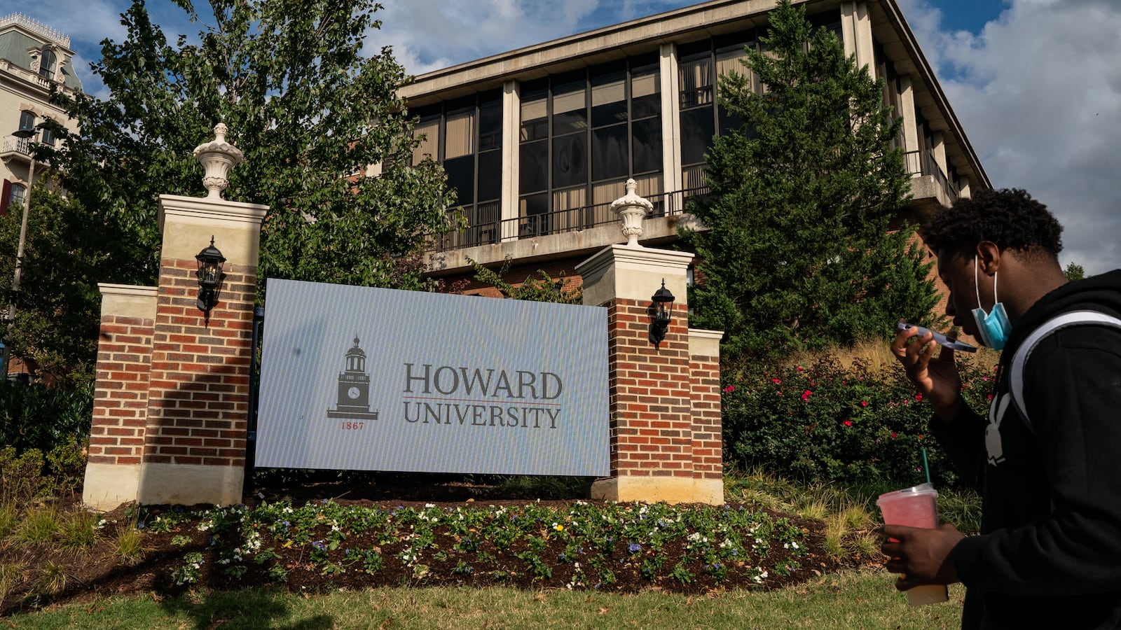A young man talks into a cell phone on the college campus of Howard University.