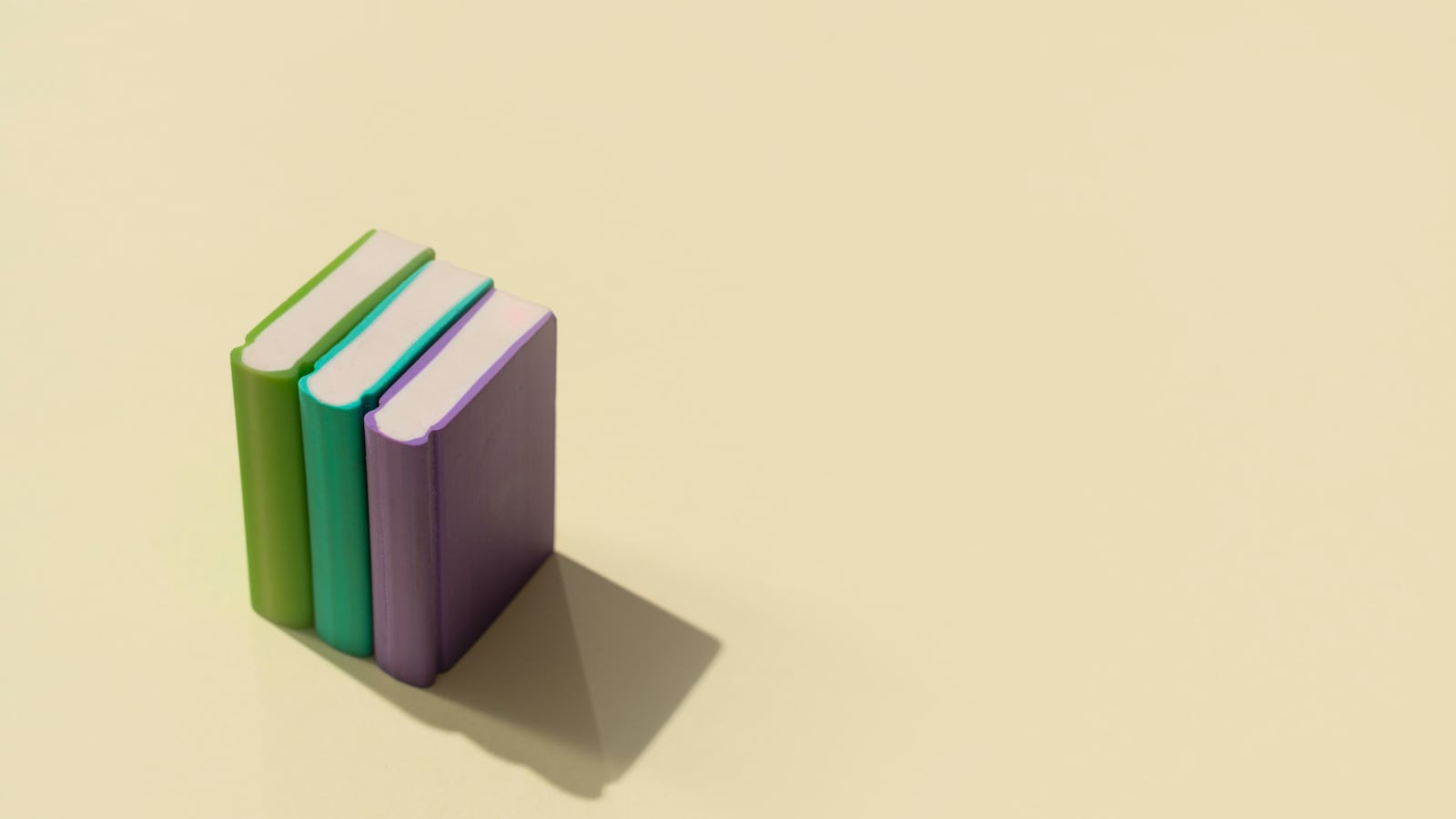Elevated view of three books on a pastel colored background