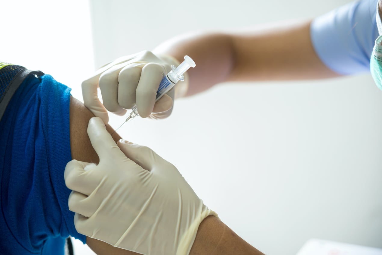 A close-up photo of a person getting a shot in the arm.