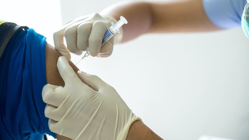 A close-up photo of a person getting a shot in the arm.