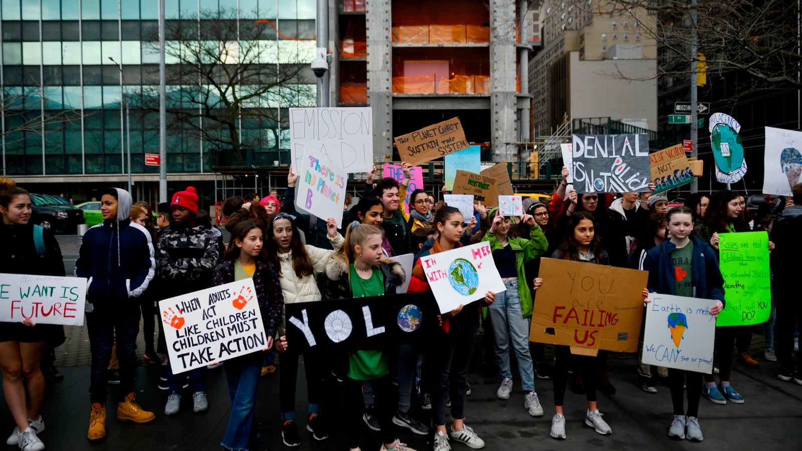 School children hold signs during a Youth Climate Strike in front of the New York Headquarters of the United Nations on March 15, 2019.
