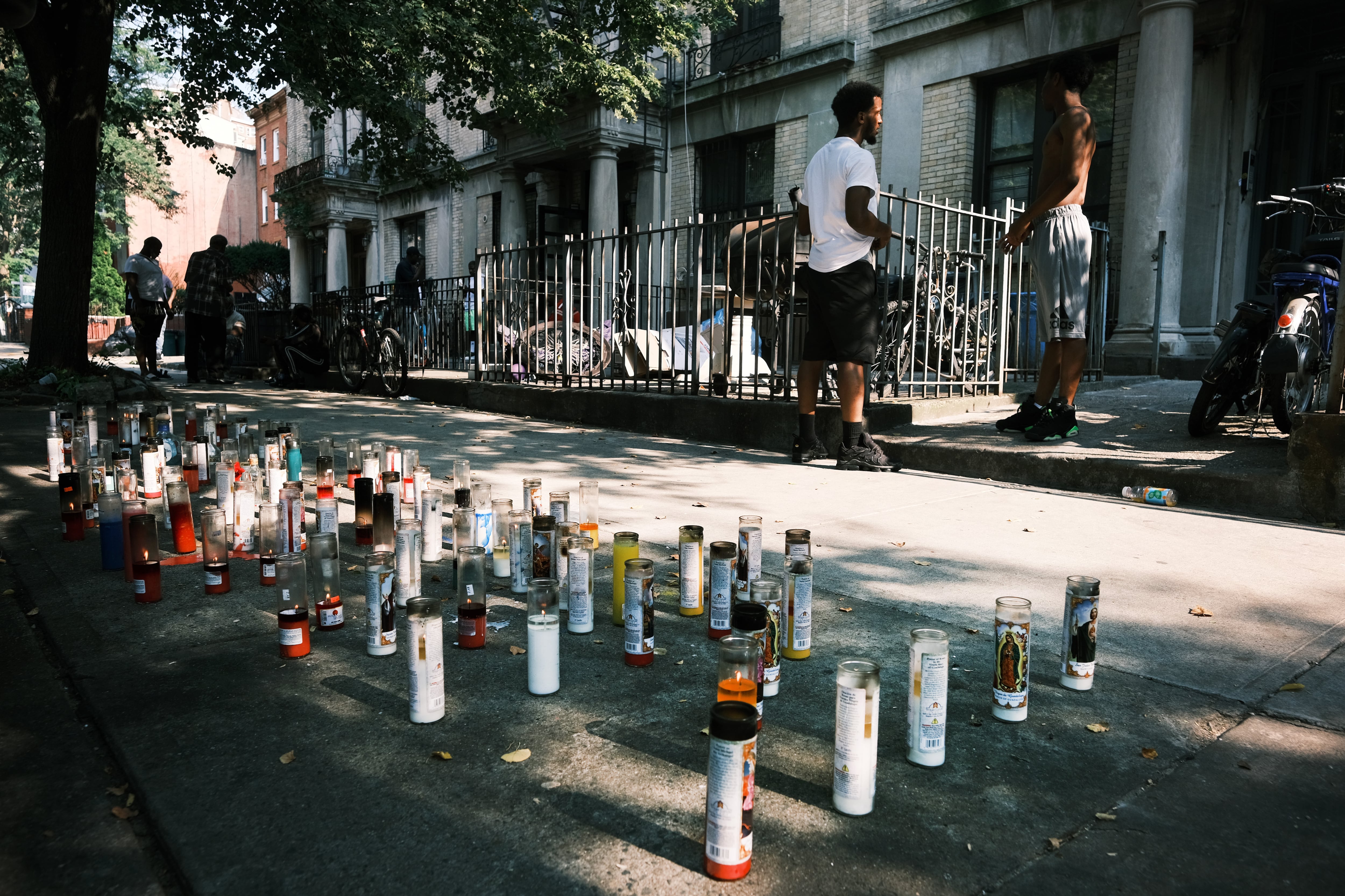 A memorial for a victim of gun violence sits on the edge of a sidewalk.