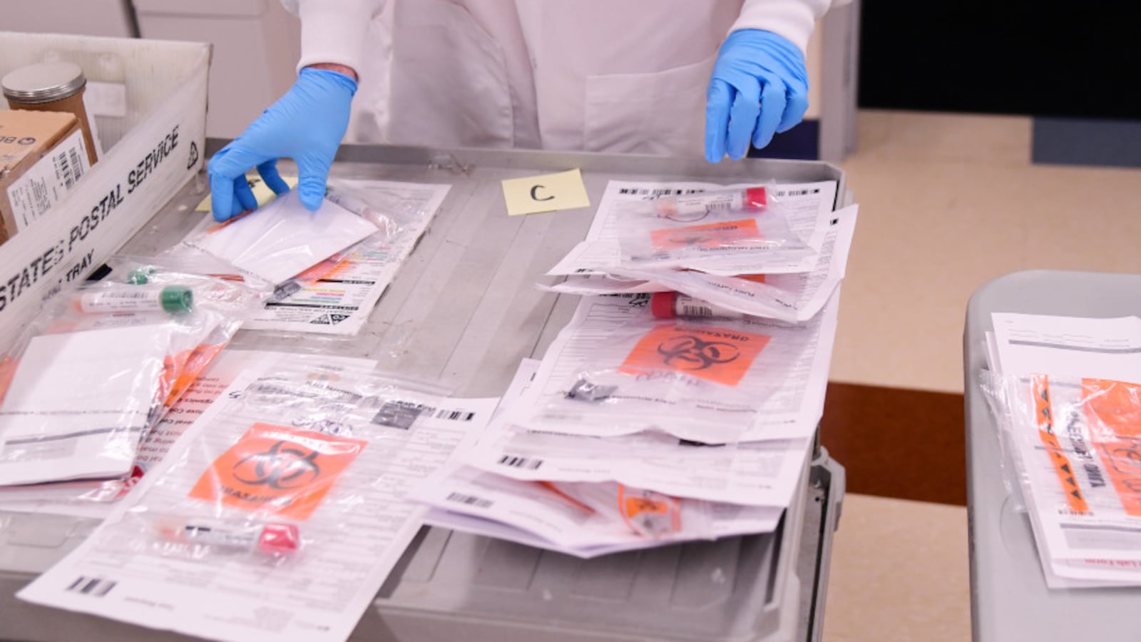 David Storey processes samples for COVID-19 at the Colorado Department of Public Health and Environment Laboratory Services Division in Denver, Colorado on March 14, 2020.