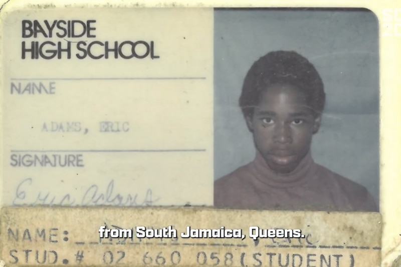A yellow and black ID card with black writing and a photograph of a young Mayor Eric Adams with dark hair and wearing a turtle neck.