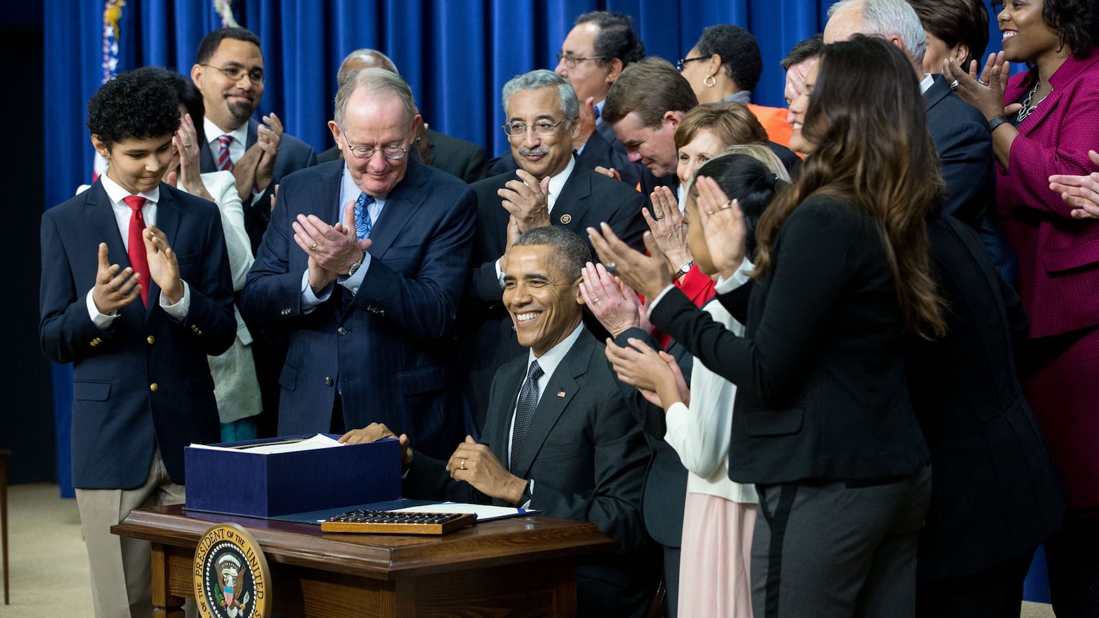 President Barack Obama signs the Every Student Succeeds Act in December 2015, surrounded by U.S. Sen. Lamar Alexander of Tennessee and other champions and supporters of the new law.