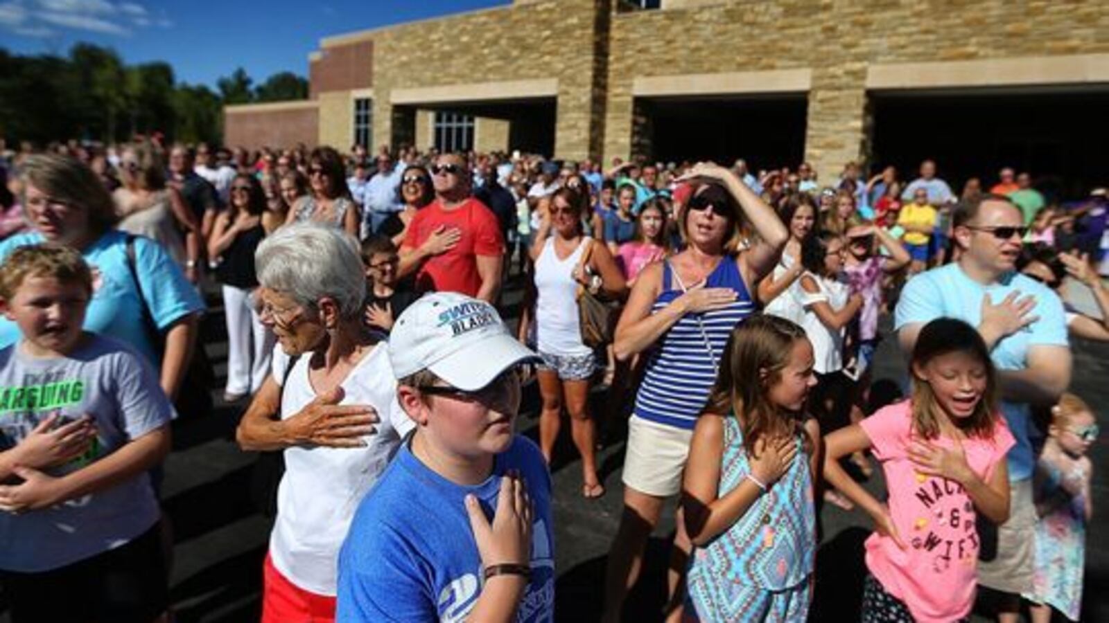 Students, teachers and parents gather for the Pledge of Allegiance outside Lakeland Middle Preparatory School during a dedication ceremony for the new school.
