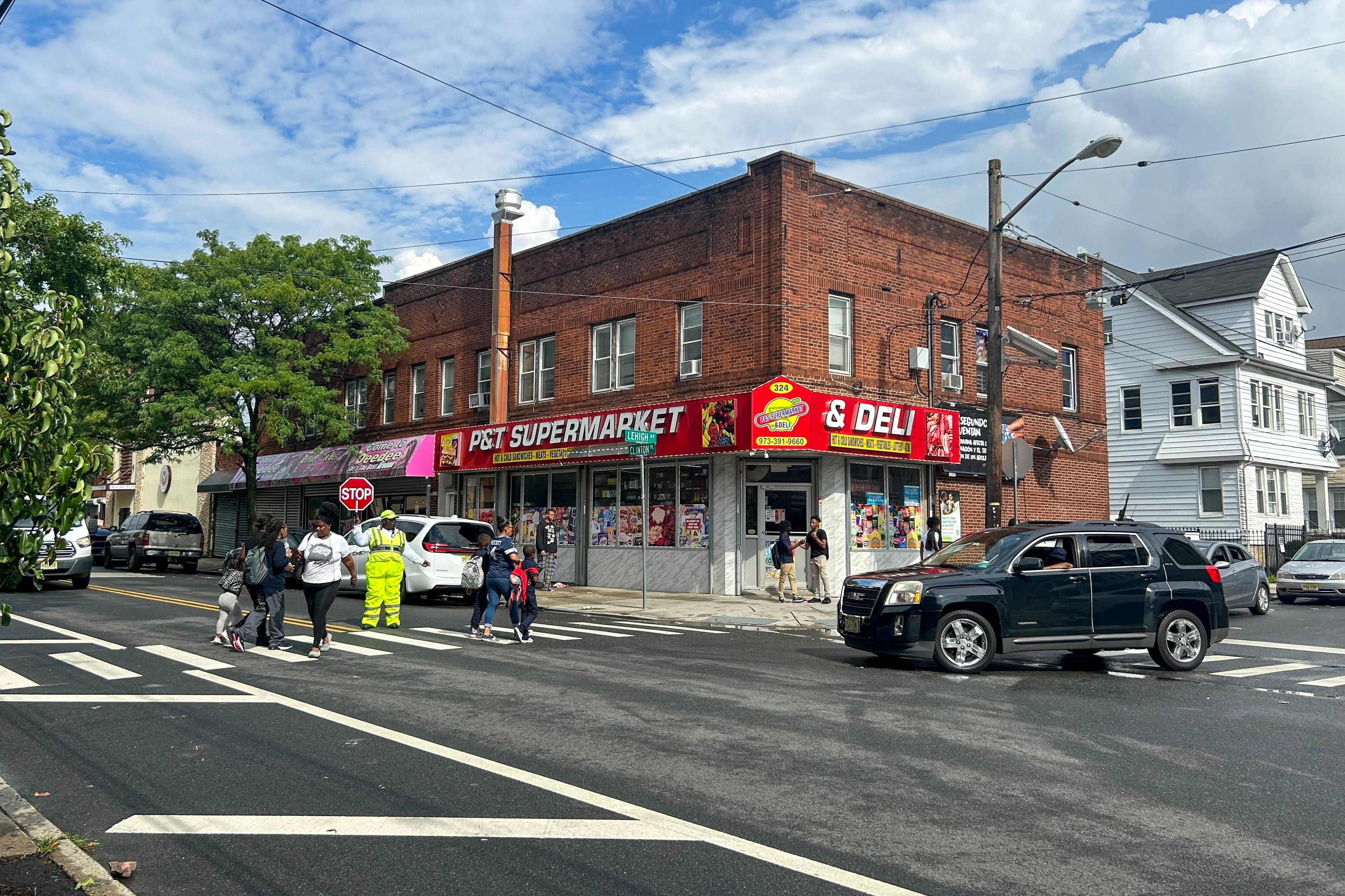 Crossing guard helps families walk busy street.