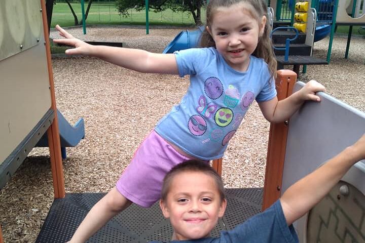 David Davis poses for photo on playground smiling with a another child