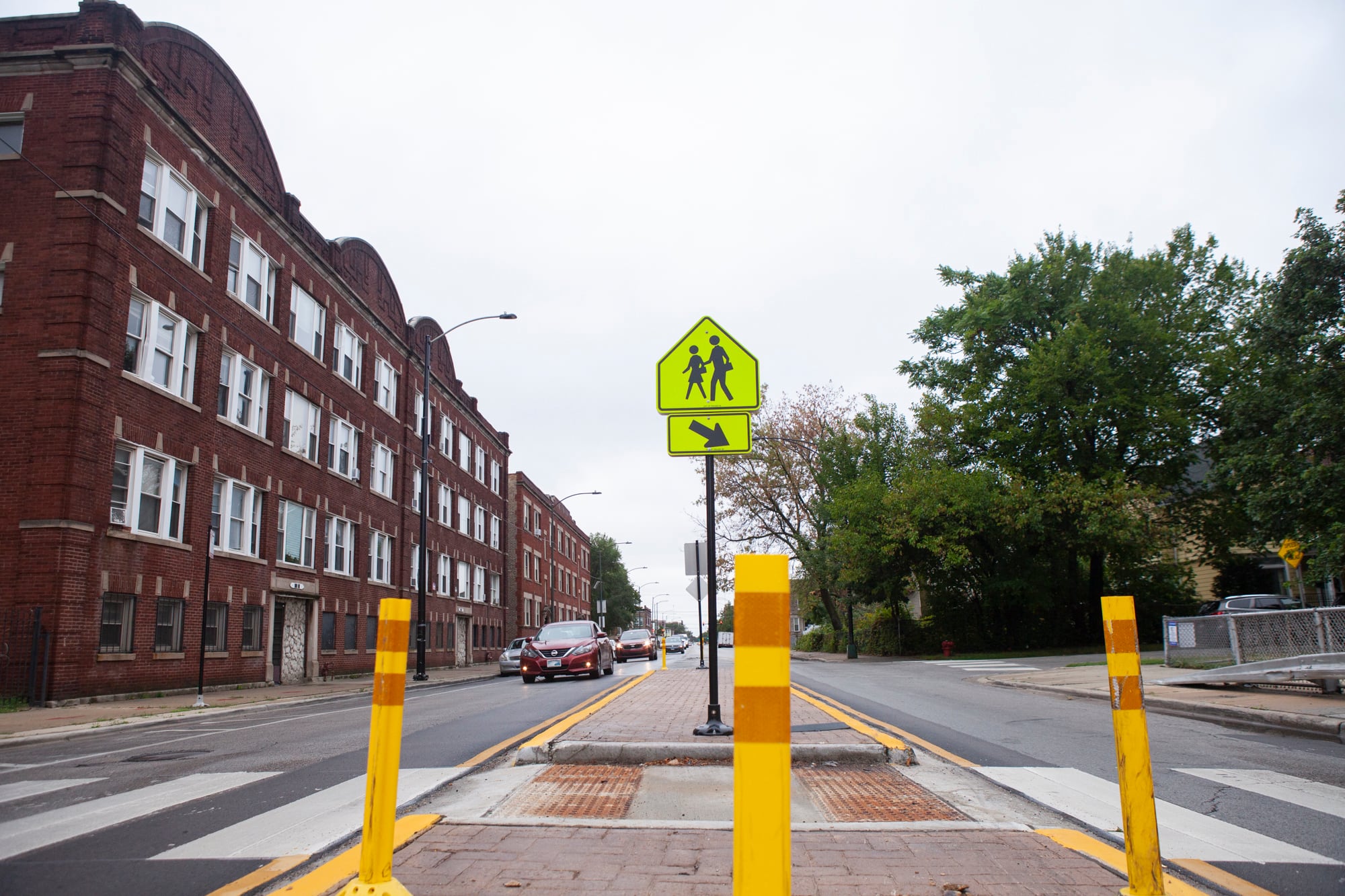 A school crossing sign in a cross walk.