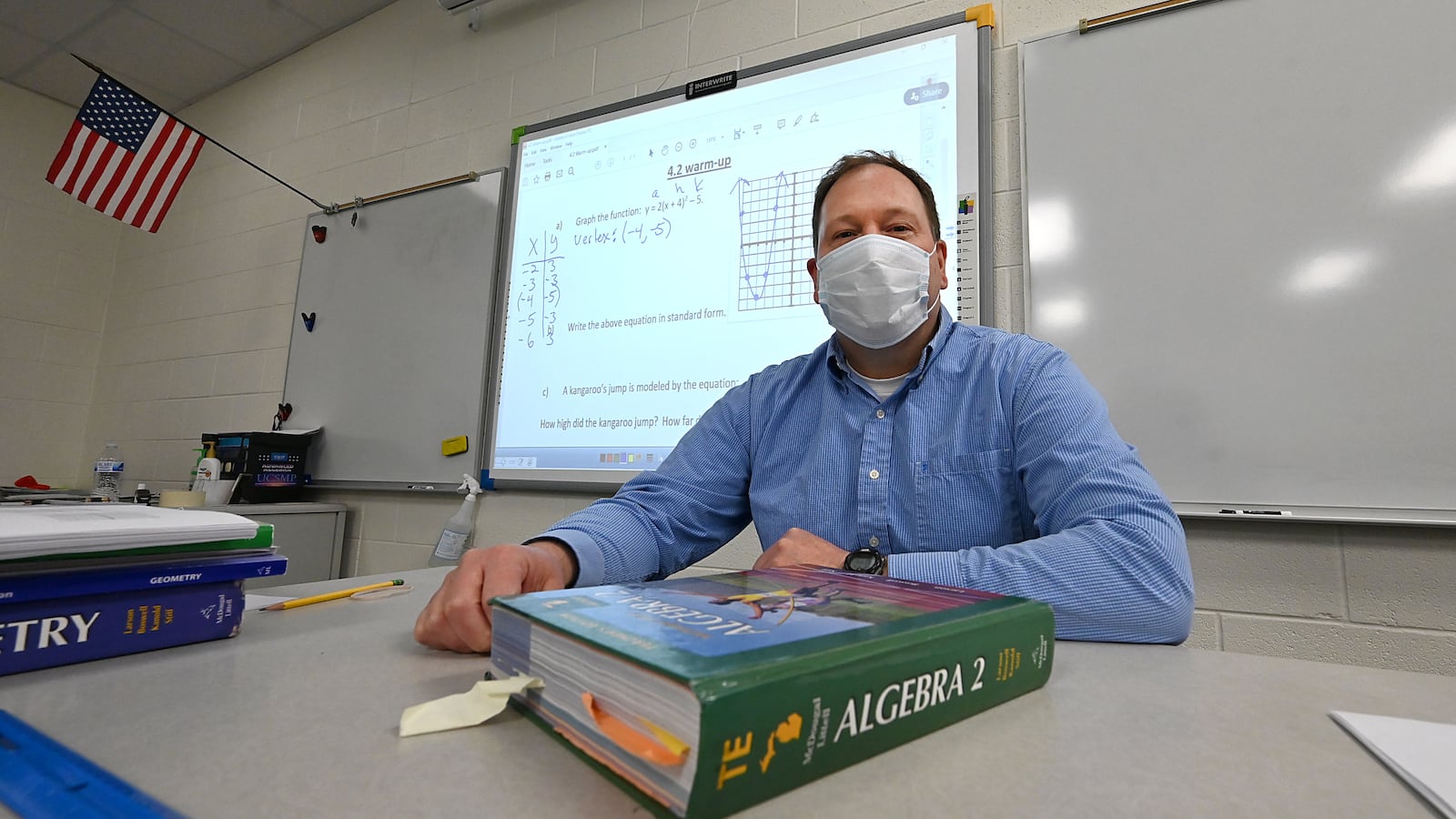 Teachers Dwight and Anne Pierson in Dwight’s classroom at St. Johns High School on Friday, March 19, 2021. Also shot of them in the library, but they could not unmask because others were using the library. Dwight uses a headset when teaching virtual classes. Anne retired from Fowler High School last year. (Dale G Young, 2021)