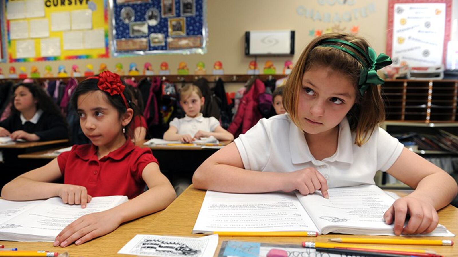 Natalia Lima Avalos, 8, left and Esperanza Gipson, 8, listen closely during their fourth grade writing class at James Irwin Charter Elementary school in Colorado Springs. (Helen H. Richardson, The Denver Post)