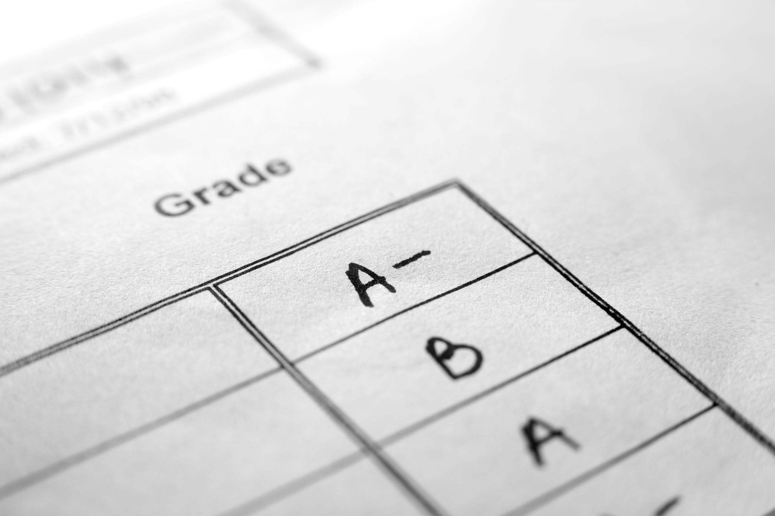 An up close photo of an "A-, B and A" on white results paper. Extremely shallow focus.