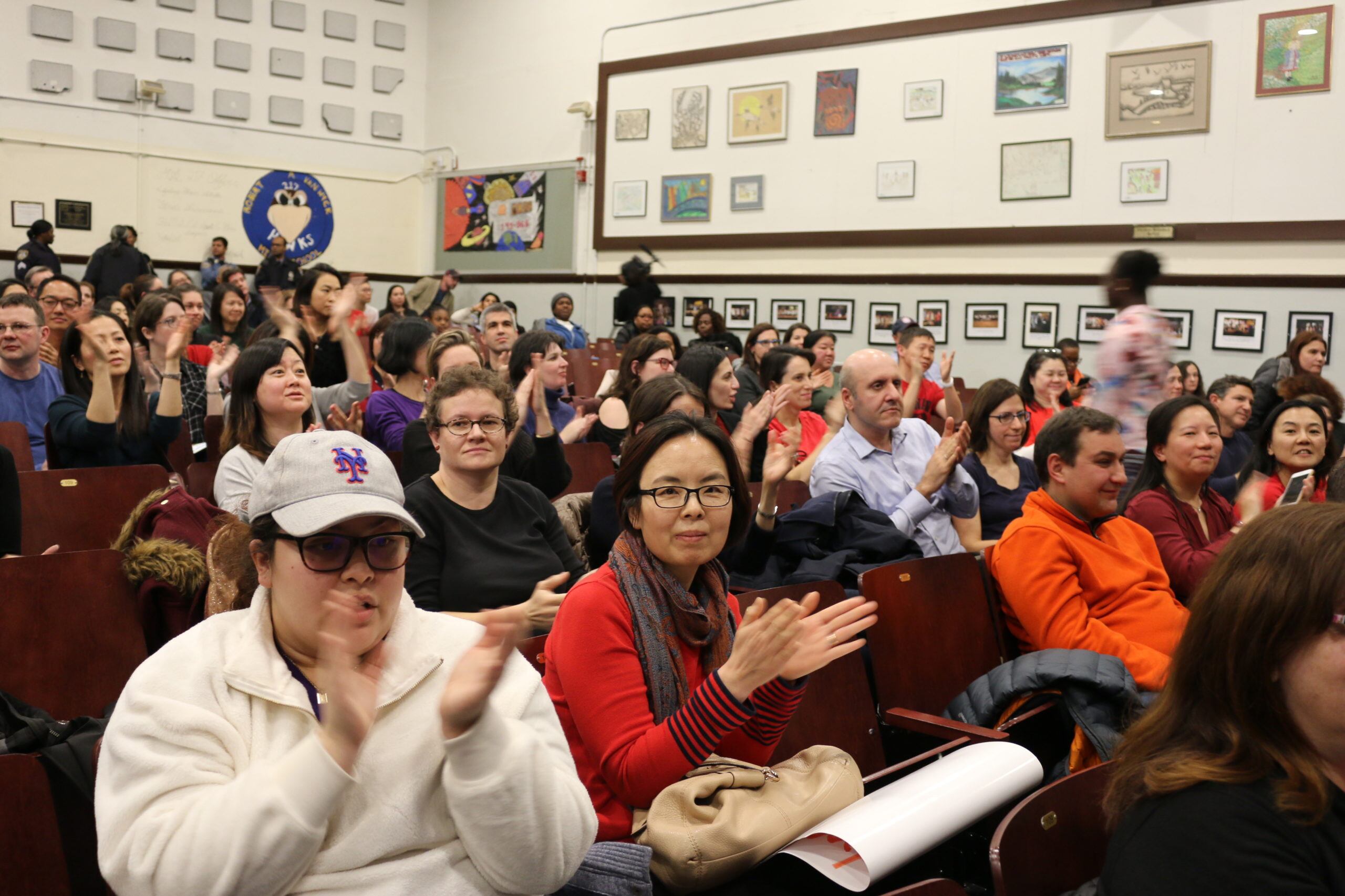 Parents in January 2020 applaud a speaker during a contentious meeting to discuss middle school integration plans for District 28 in Queens. Fights how to make New York City schools more representative of student demographics have filtered down to the races to elect Community Education Council members.